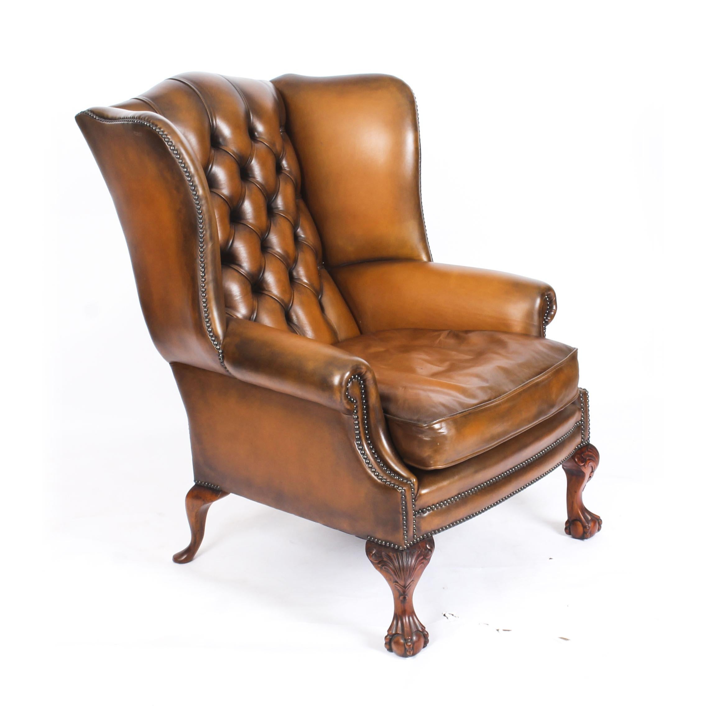 This is an absolutely fabulous pair of antique English leather wingback Chippendale Revival armchairs, circa 1920 in date.

They stand on hand carved solid mahogany ball and claw cabriole legs with acanthus decoration.

The leather is of superb