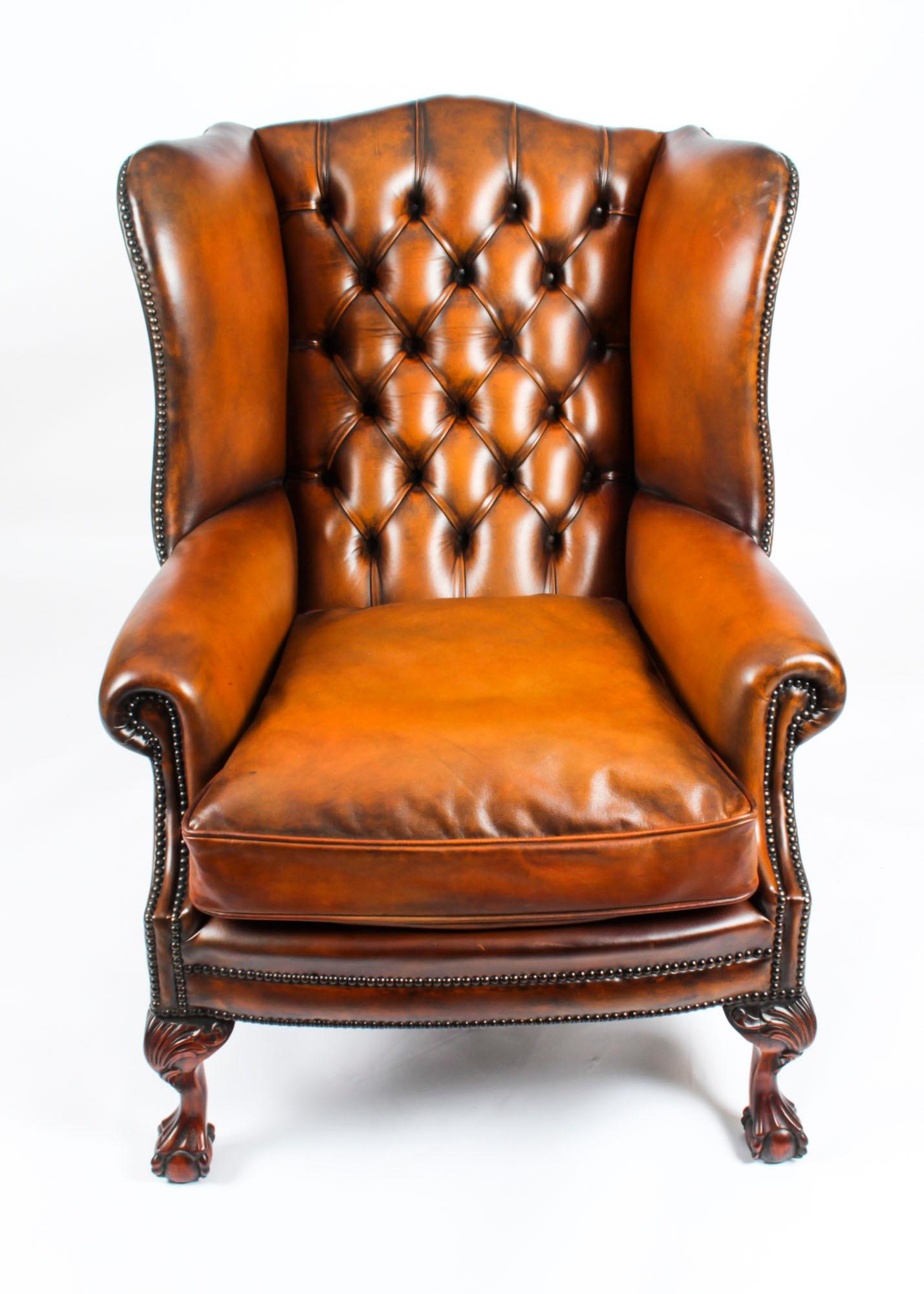 This is an absolutely fabulous pair of antique English button back leather wingback Chippendale Revival  armchairs, circa 1920 in date.

They stand on hand carved ball and claw cabriole legs with acanthus decoration.

The leather is of superb