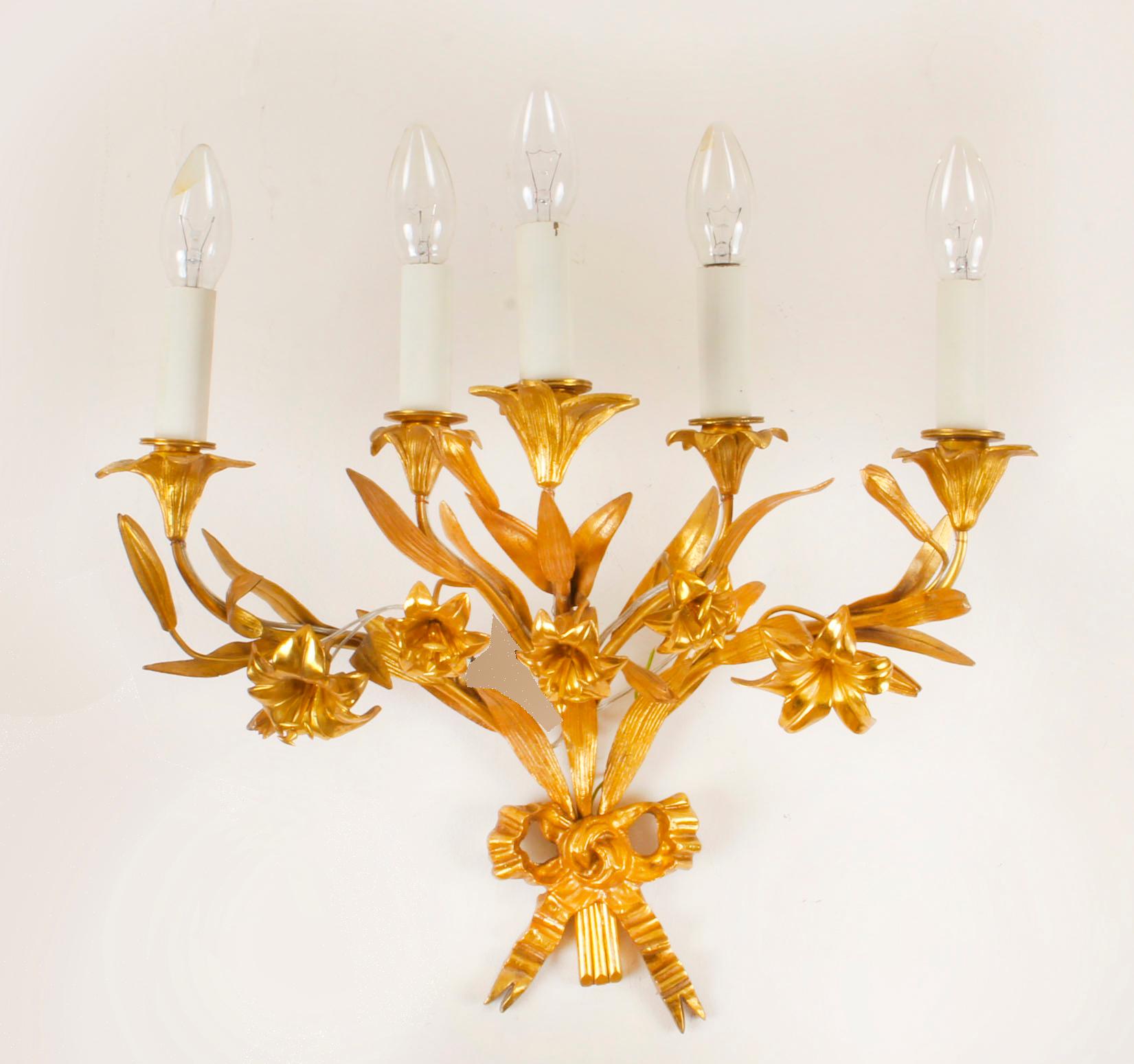 This is a pair of superb antique Louis Revival ormolu five branch wall lights, circa 1920 in date.
 
The lights feature scrolling arms with blossoming foliate and floral ornamentation, including the drip pans with a ribbon and bow to the base.
