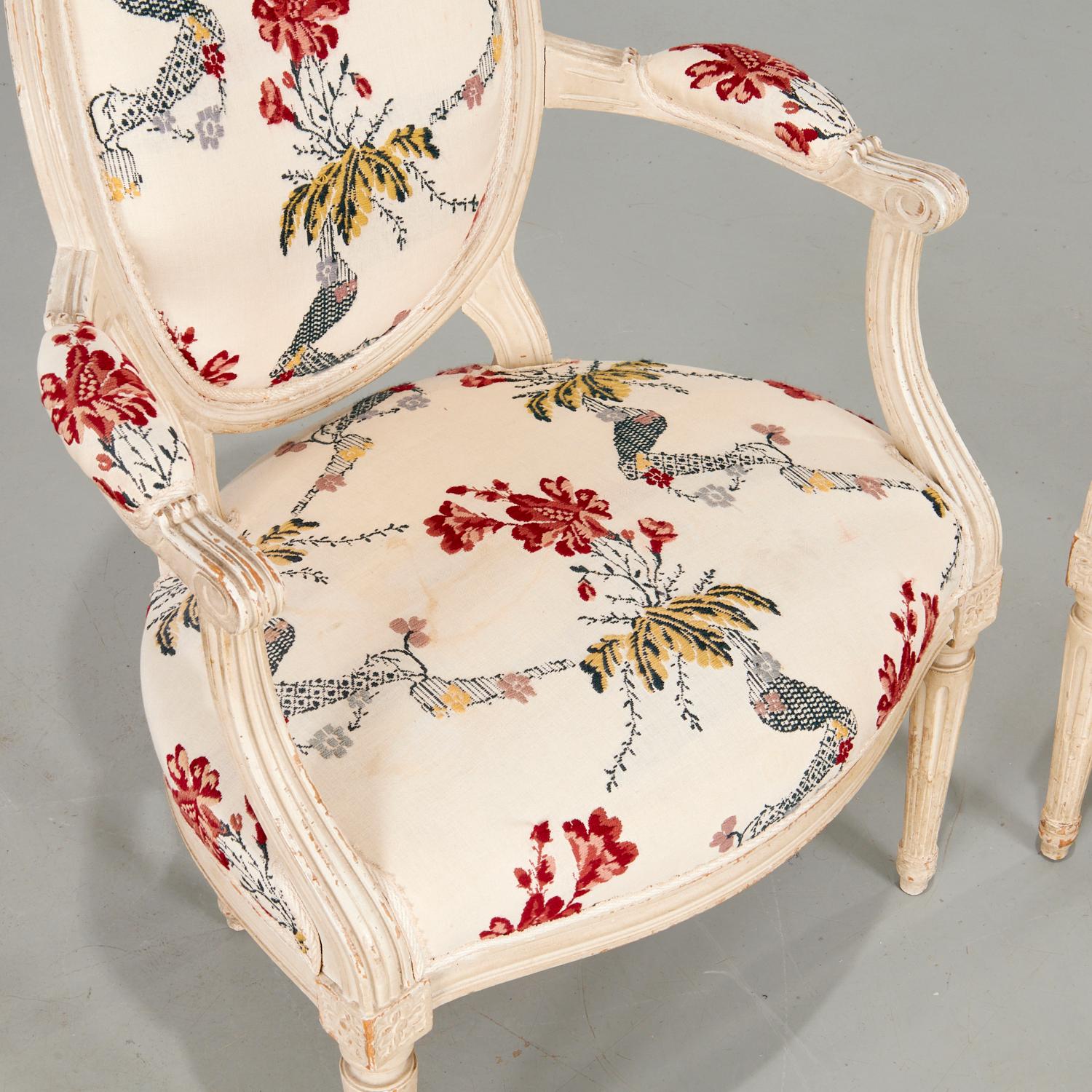 Ein Paar bemalte Fauteuils im Stil Louis XVI aus dem 19. Jahrhundert mit floralen Stickereien aus dem 20.  Polsterung von Sitz, Rückenlehne und Armlehnen. Die Rückenlehne des Stuhles ist mit einem komplementären karierten Stoff gepolstert.

Es gibt