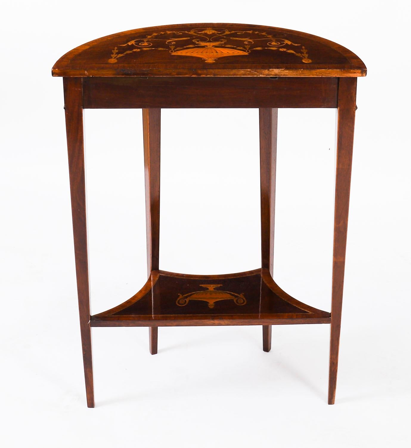 A fine pair of Victorian flame mahogany and marquetry demi-lune console/ bedside tables by the renowned cabinet makers Edwards and Roberts, circa 1880 in date.
 
Made in the manner of Thomas Sheraton they each feature a crossbanded top above a
