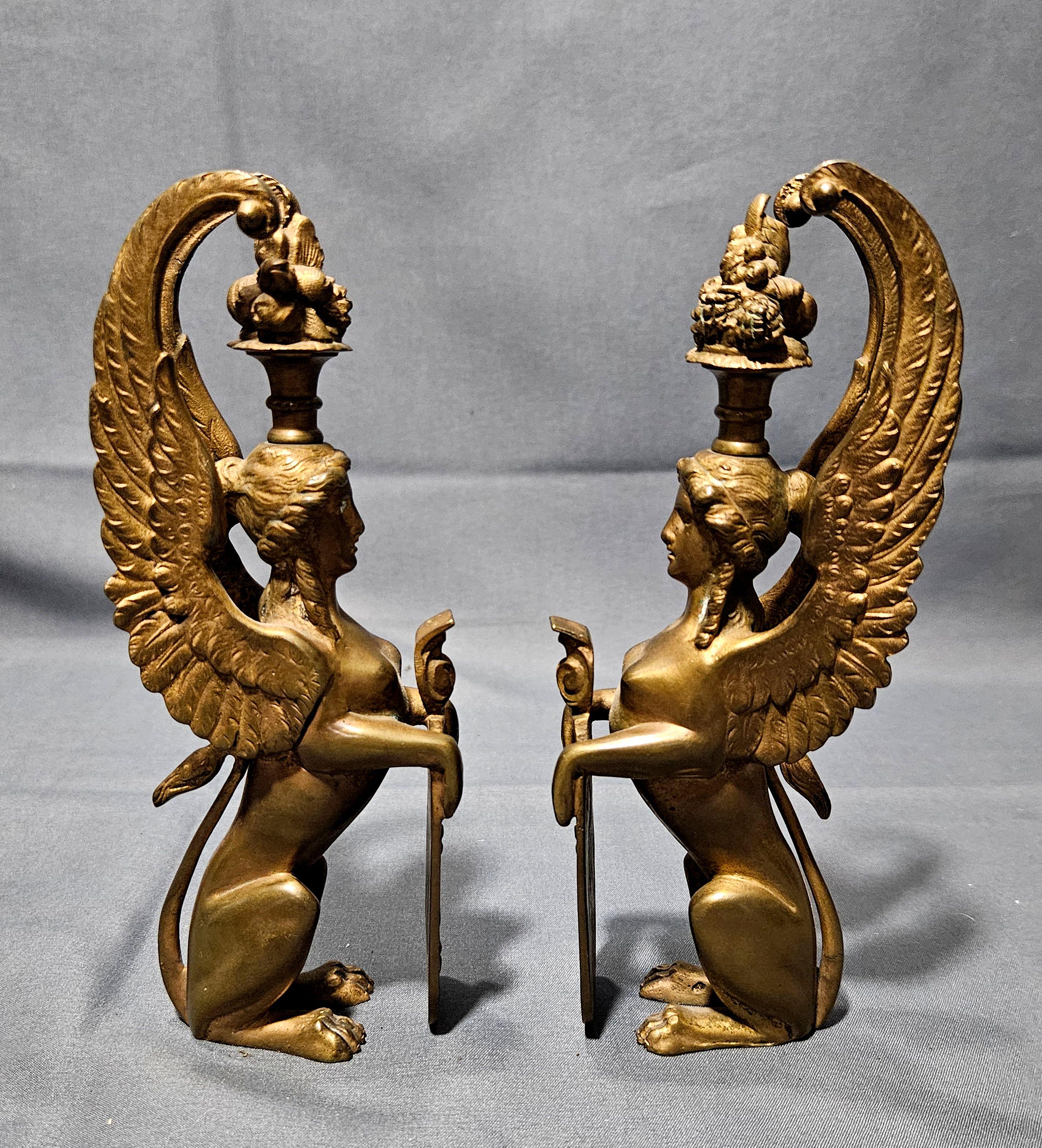 Antique Pair of Matching Solid Gilt Bronze Female Winged Griffins Sphinx, Greek Egyptian Harpies, each holding a shield with wing torch,

Harpies can refer to figures in Greek mythology, large birds of prey like the harpy eagle, or monstrous