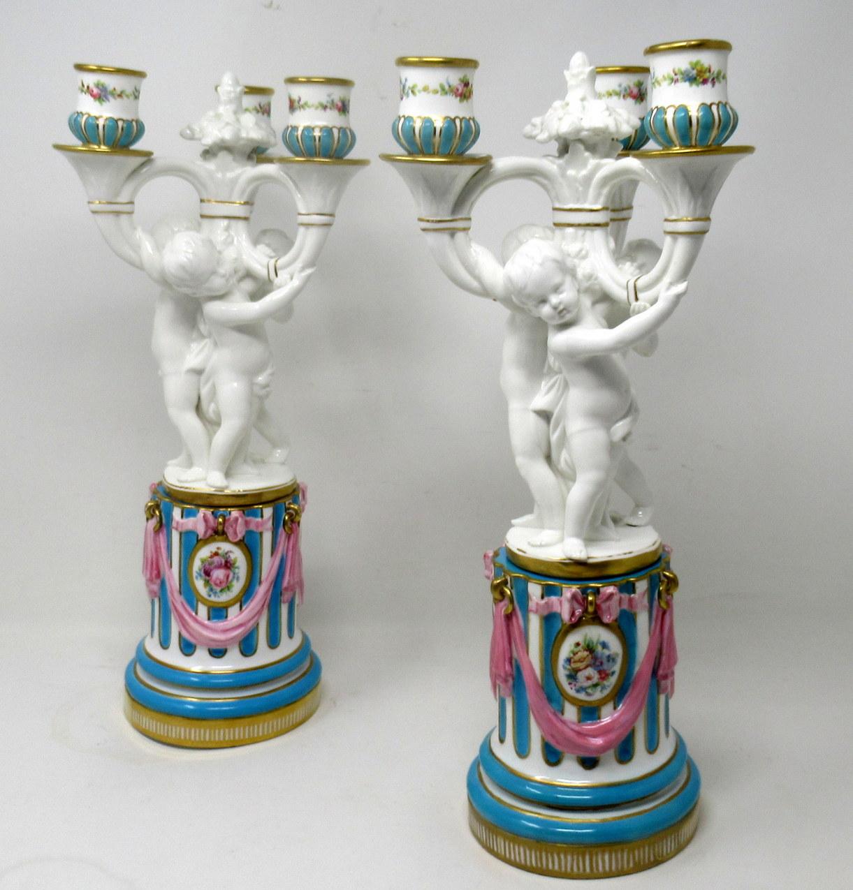 Stunning example of a pair of English Minton porcelain three branch candelabra, each modelled as a group of Cherubs standing on naturalistic base above an elaborate reeded socle with lavish decoration depicting gilt framed medallions with hand