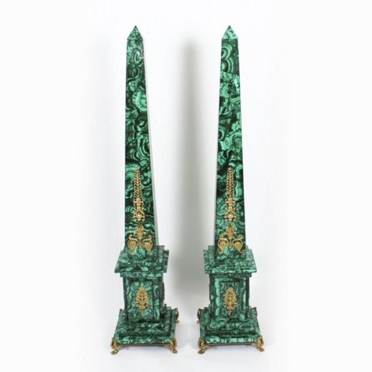 A monumental pair of Neoclassical ormolu mounted malachite obelisks on mahogany pedestals, circa 1920 in date.
 
The square conforming malachite columns taper to pyramid shapes with applied decorative gilt ormolu mounts.
 
The obelisks stand on