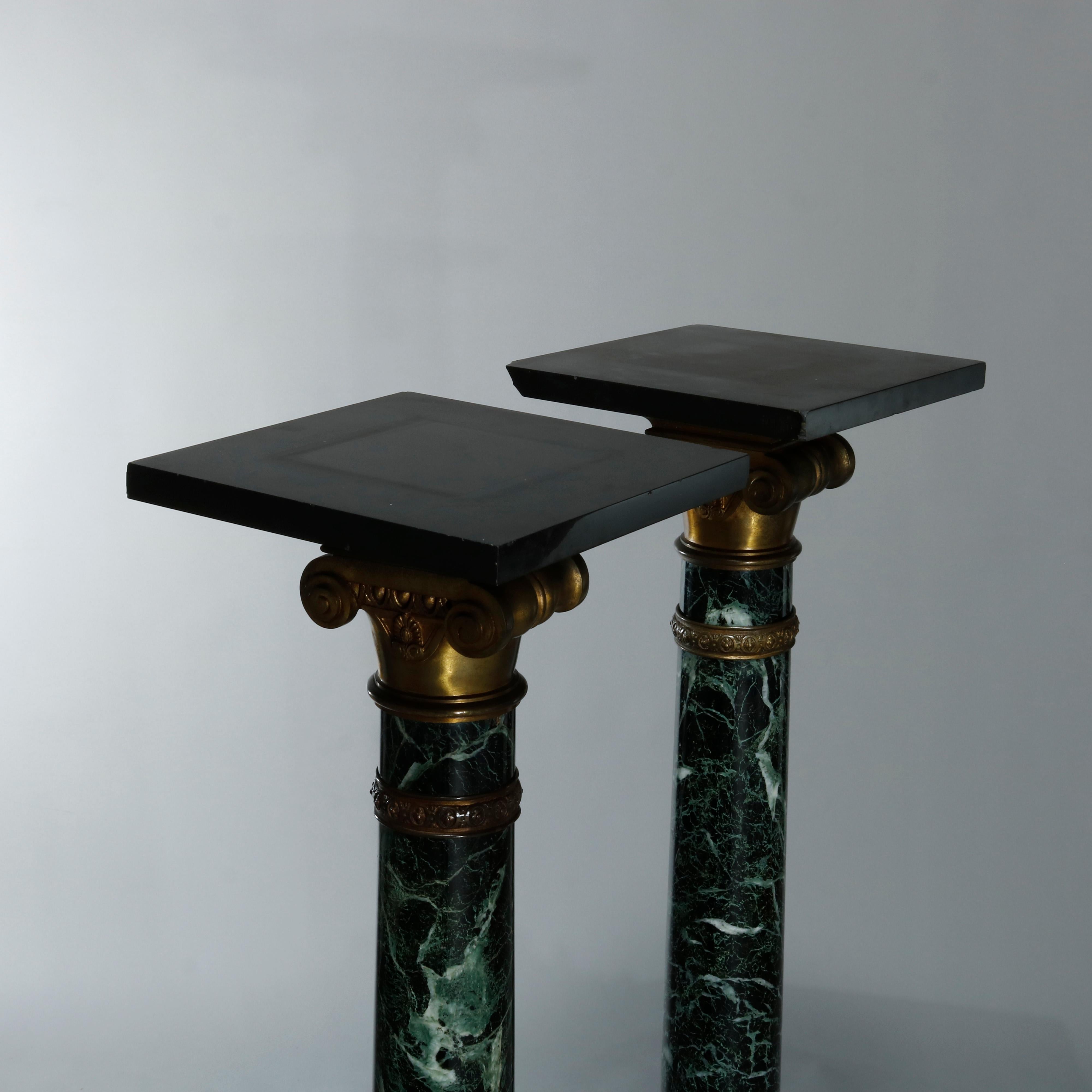 An antique pair of Neoclassical carved marble sculpture display pedestals offers Corinthian style columns with foliate cast bronze scrolled capitals and seated on square base raised on scroll form cast bronze feet, cast bronze mounts throughout,