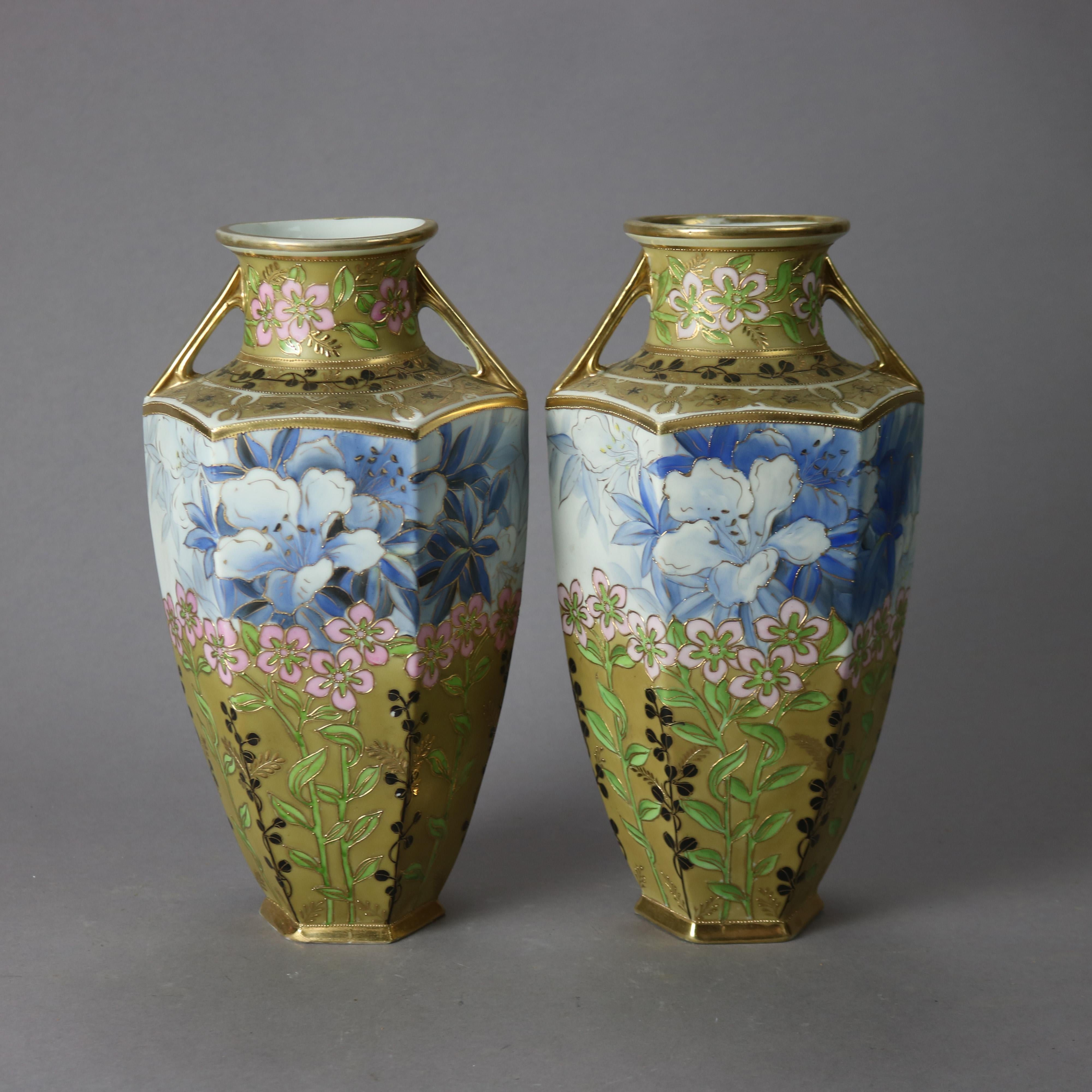 An antique pair of Japanese Nippon vases offer porcelain construction in hexagonal form with double handles, hand painted and enameled floral design, and gilt highlights throughout, maker mark on base as photographed, c1920

Measures - 12.75