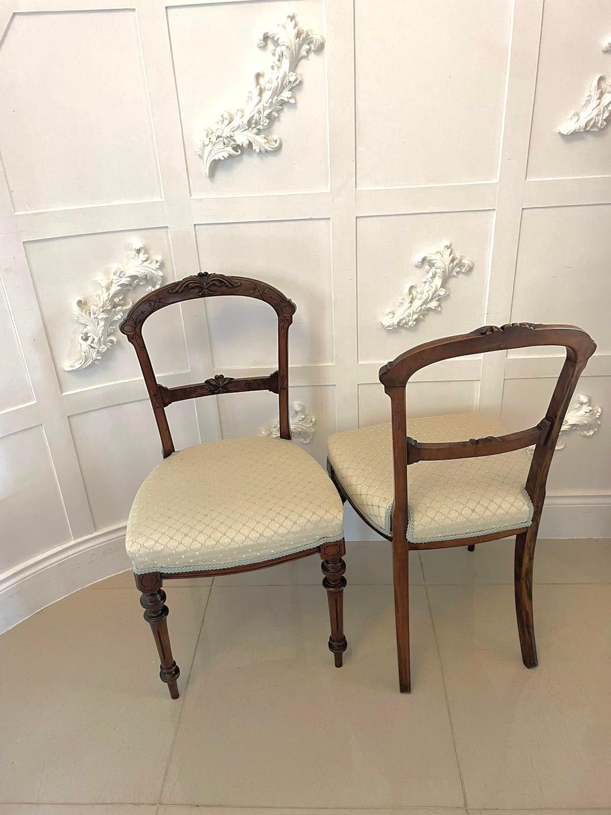 Antique pair of 19th century Victorian antique walnut side / desk chairs with elegantly carved walnut shaped backs and newly reupholstered seats in quality fabric. The chairs stand on turned reeded legs to the front and out swept back