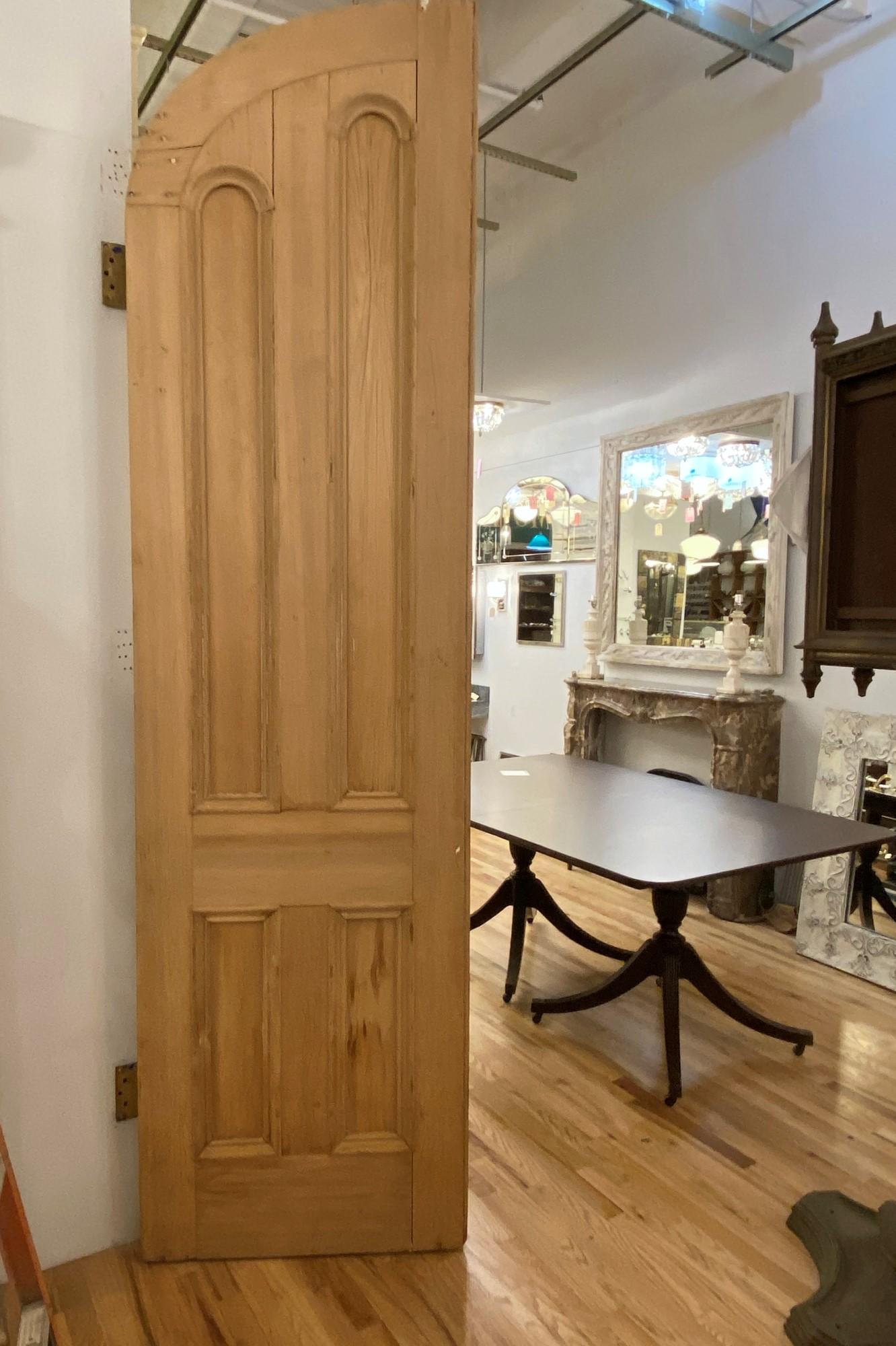 Late 19th century pair of arched pine parlor doors. These feature 4 flat vertical panels on each door side. These have been stripped. This can be seen at our 333 west 52nd St location in the Theater district west of Manhattan. Measures: 107.5 in. L