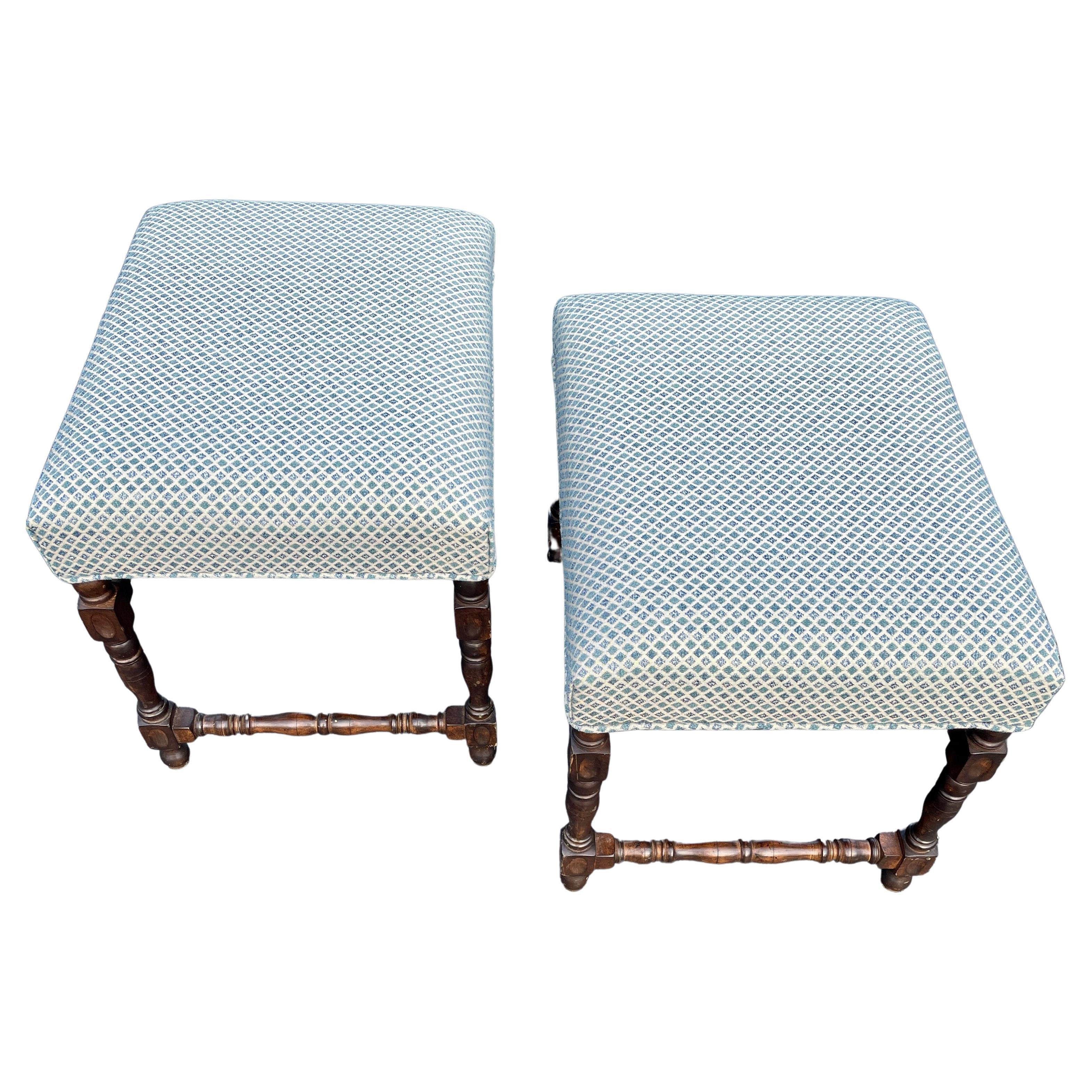Late 19th Century antique barley twist ottomans or stools. Newly upholstered. This traditional yet chic pair of stools or ottomans consists of barley twist legs and stretchers, with new blue and cream linen upholstery.