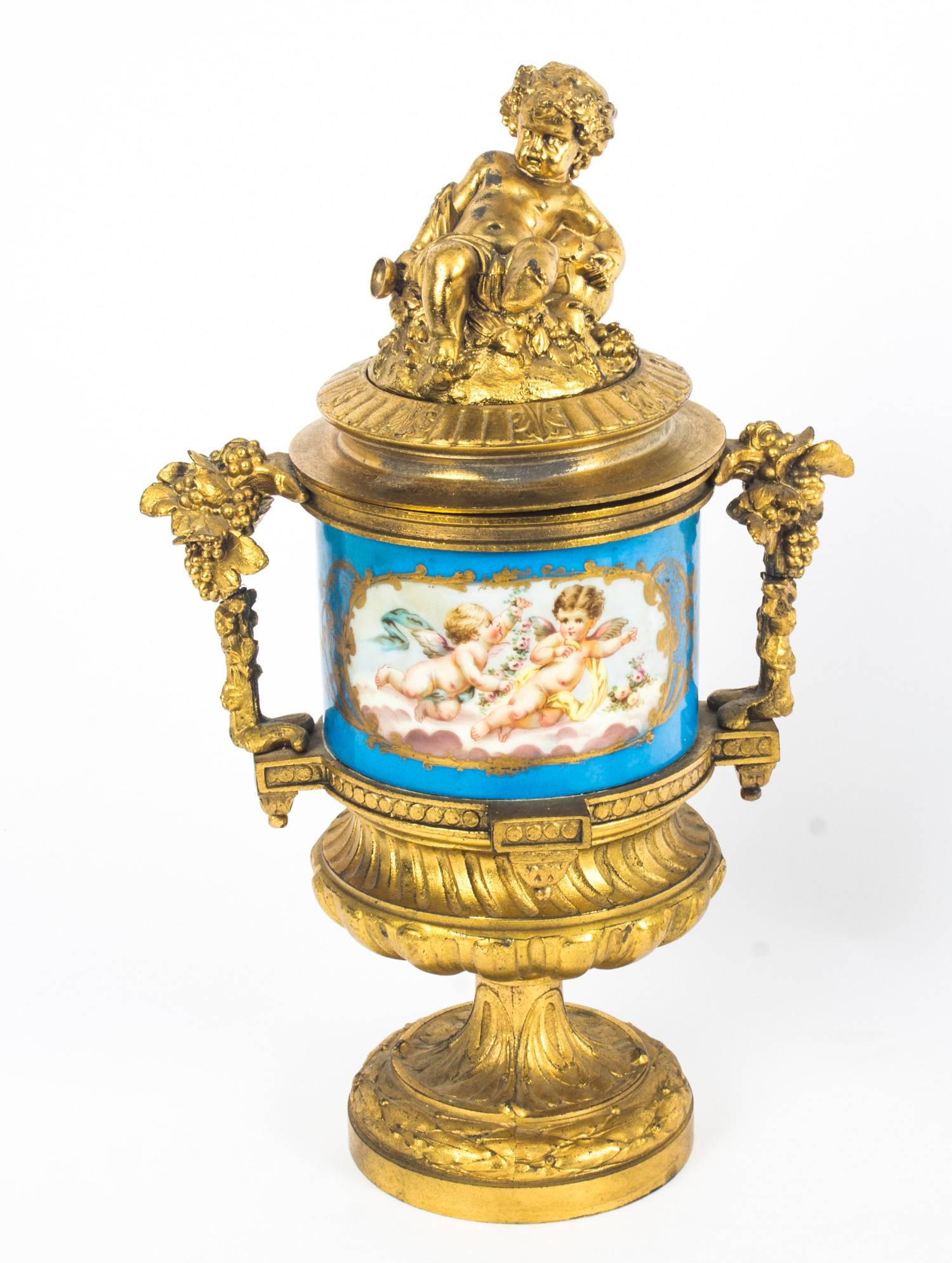 This is a stunning pair of French twin handle ormolu garniture lidded urns, with Sevres hand painted porcelain, in the manner of PH Mourey, circa 1870 in date.

The ormolu handles with grape vine decoration and the ormolu lids with seated cherubs.