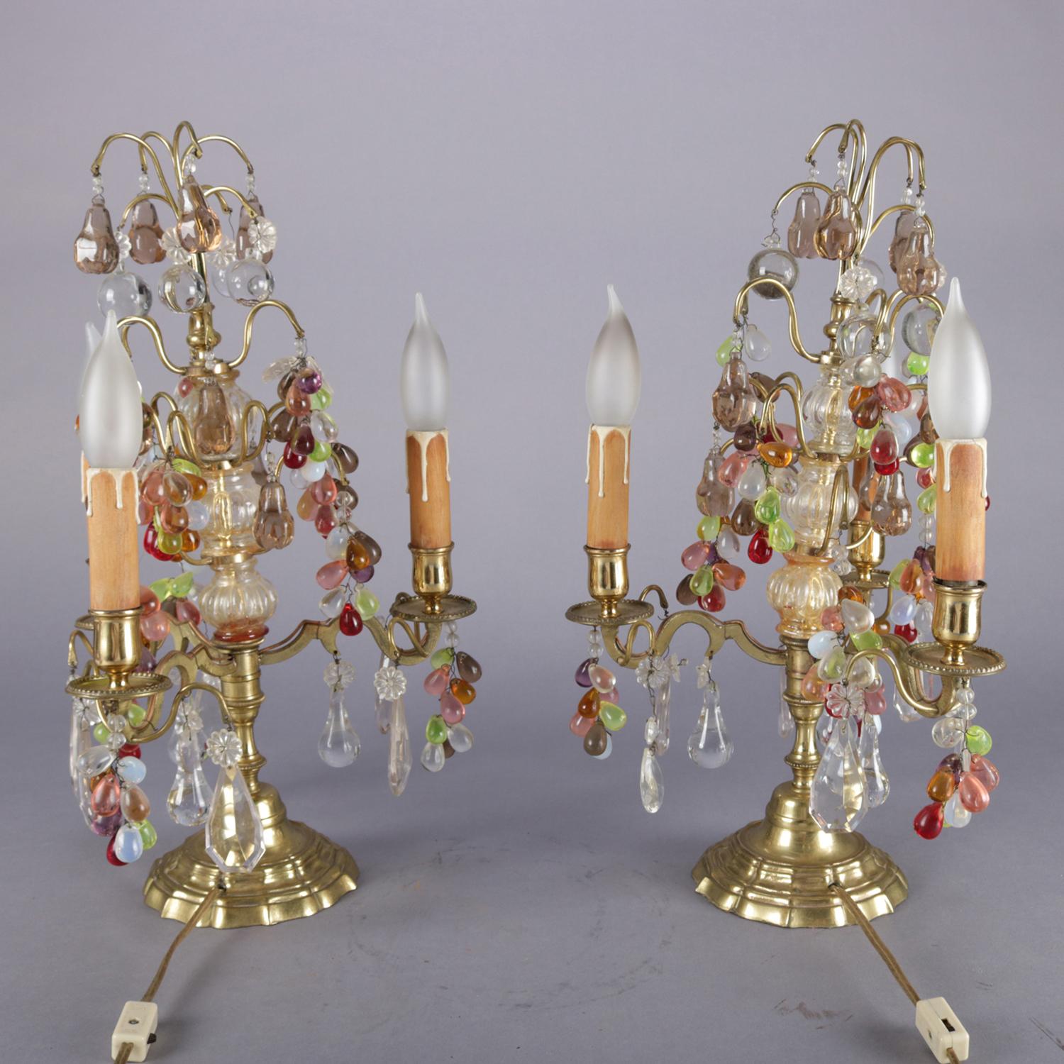 Antique pair of fruit candelabra lamps feature bronze frame with three arms terminating in drip candle lights and having multicolored teardrop prism clusters in grape form, circa 1900.

Measures: 18
