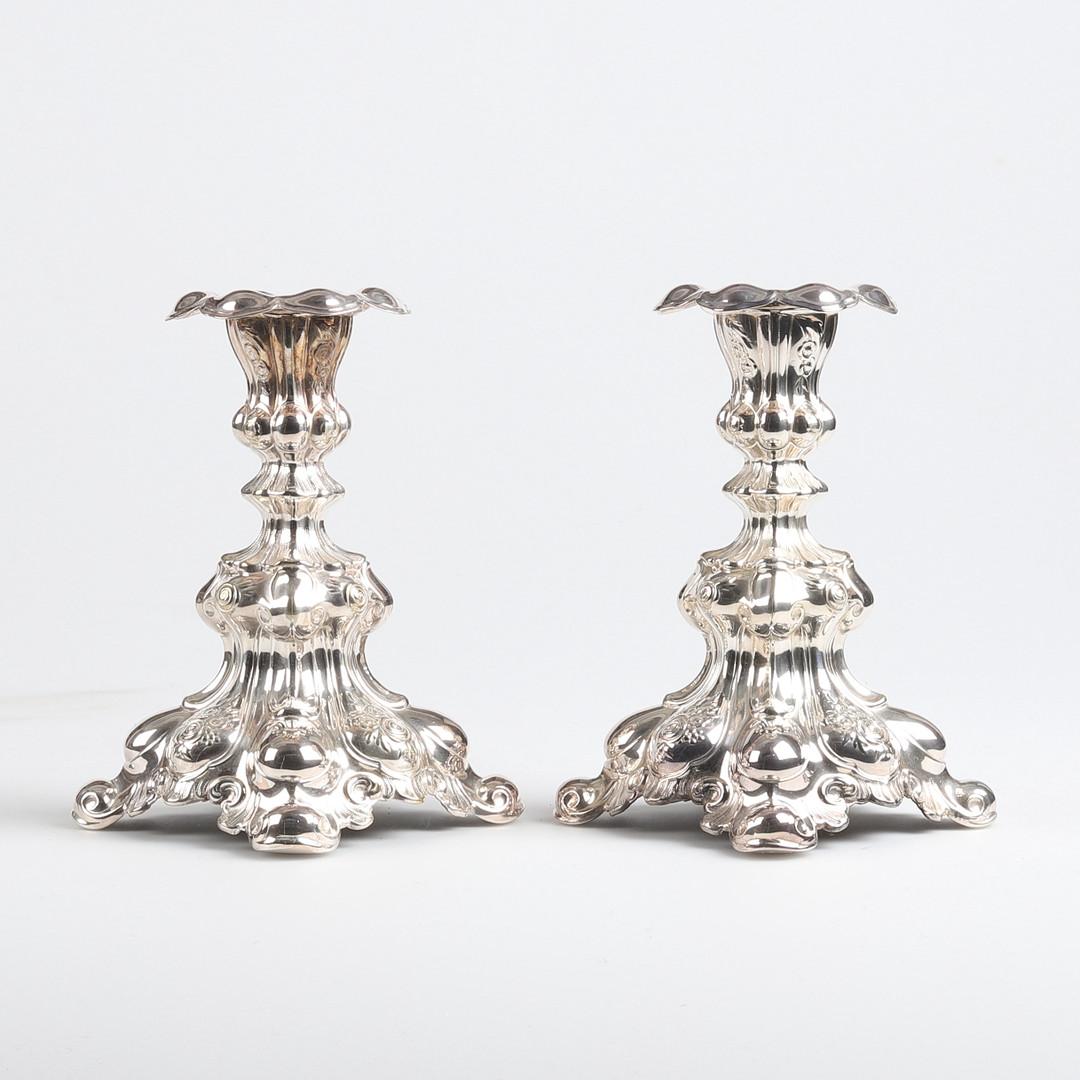 Un ensemble de 2 CG Hallberg en argent, une paire de chandeliers en argent de style Rococo, pressés, moulés et ciselés. Pieds circulaires et incurvés avec charnières. Testé avec le scratch test, hauteur environ 18 cm, diamètre 10 cm. Des courbes en