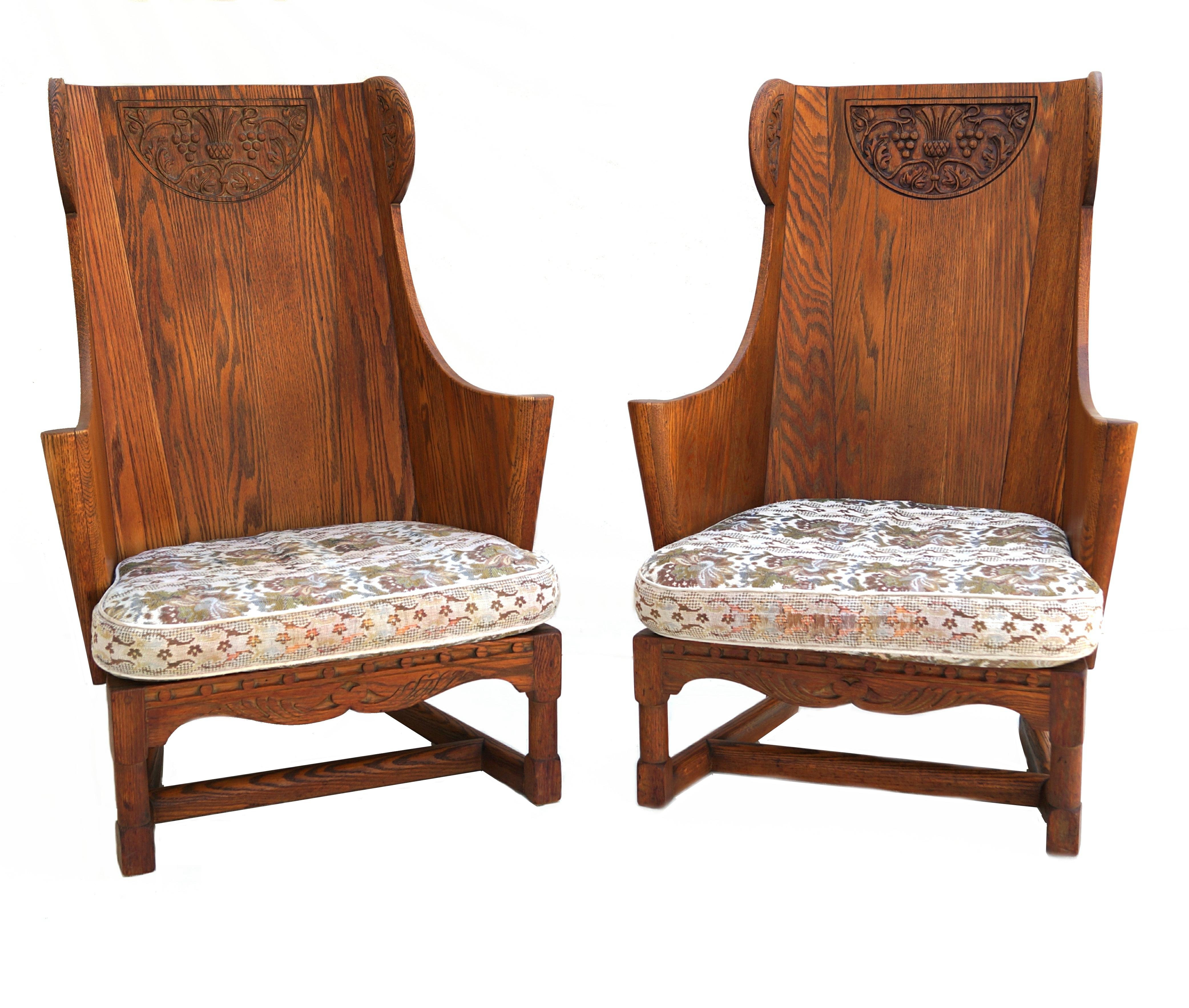 Antique pair of paneled wood wing chairs by Jamestown Lounge Company, with angled legs and base with tall back with curved sides, scrolled arms and detailed carved panels around the top with dovetail workmanship.