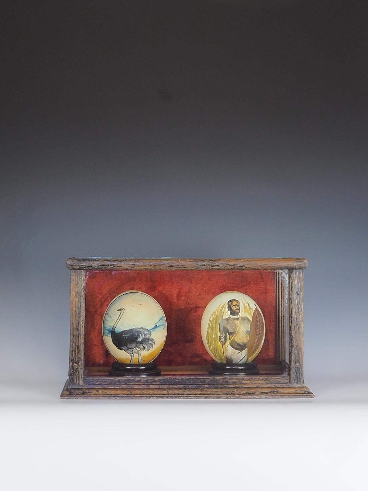 These antique pair of cased South African ostrich eggs is a unique and exquisite addition to any collection. The eggs are hand-painted with intricate designs, showcasing the talent and skill of the artist. The attention to detail is evident in every
