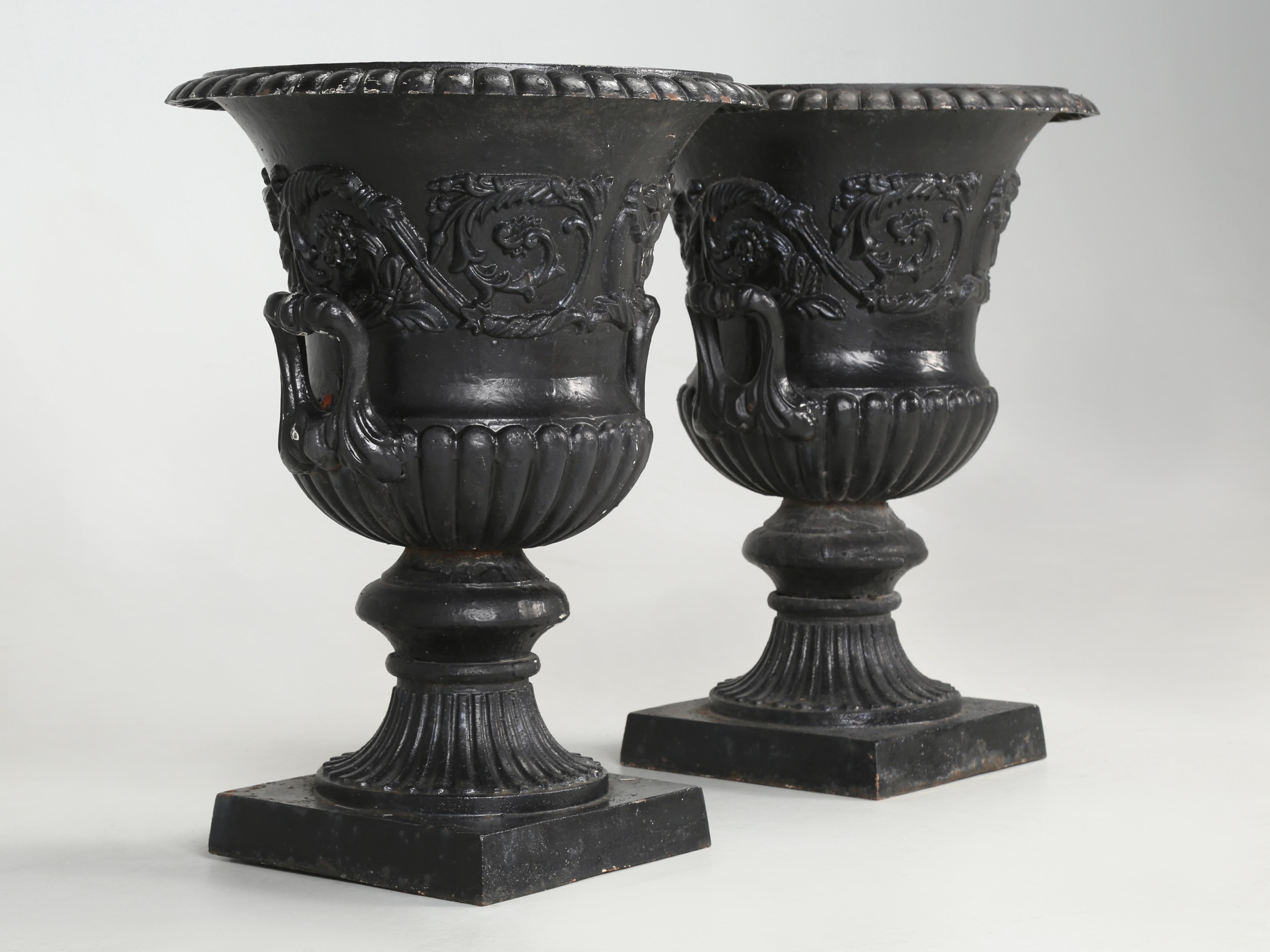Pair of antique French cast iron garden urns in old paint. Please look at the top rim of one urn and you will note a prior repair that was done correctly by welding. There is also a hairline crack near the base on one urn.
**The bases are 10.5