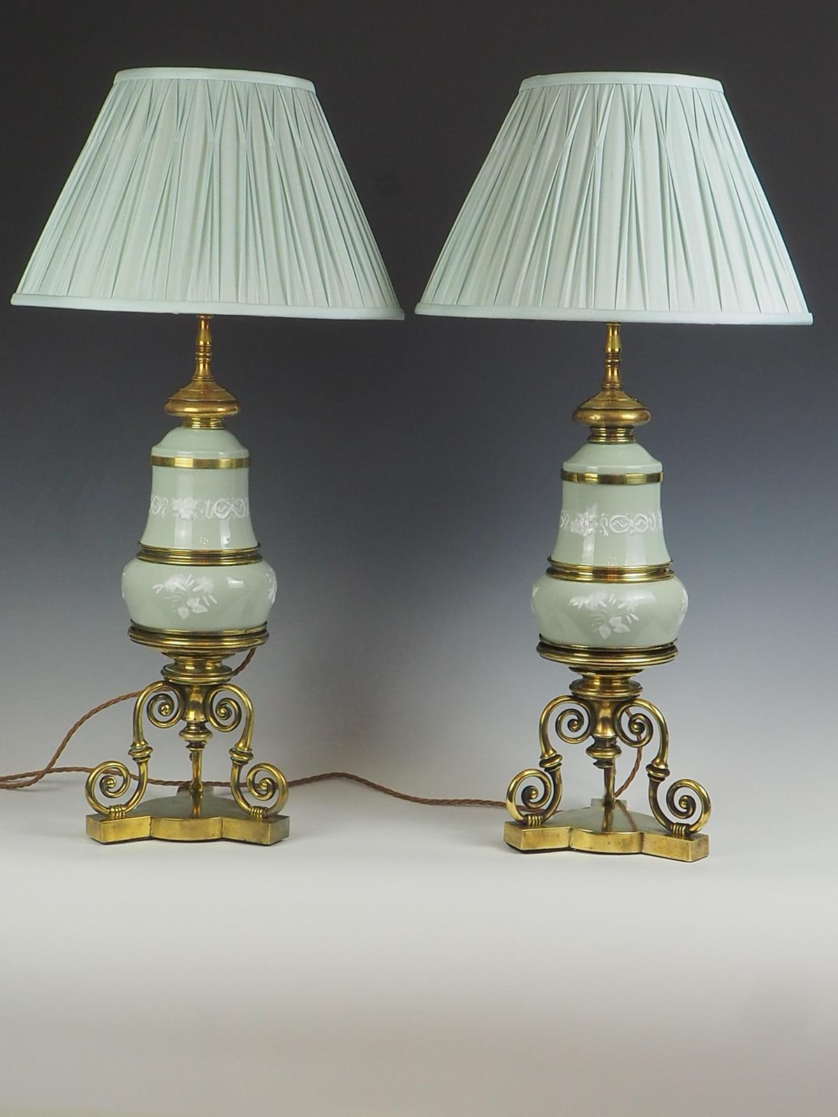 Pair of Celadon Porcelain Table Lamps is sure to captivate your guests with its exquisite design. Crafted with meticulous attention to detail, these lamps feature delicate white flowers and elegant ribbons on the porcelain, adding a touch of grace