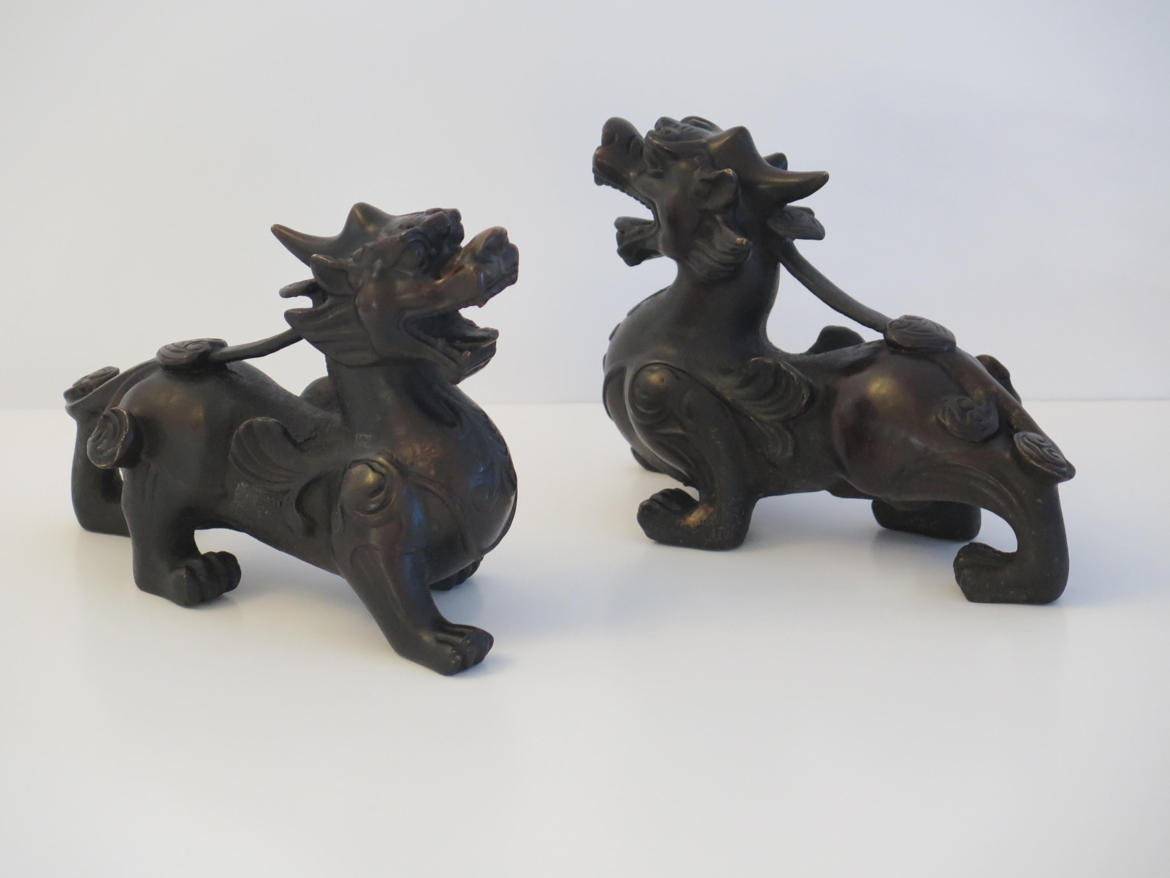 These are a very good pair of antique Chinese foo or lion dog sculptures, sometimes called temple lions, made of bronze, with good detail, which we date to the Qing dynasty, late 18th to early 19th Century.

These pieces are well cast with very good