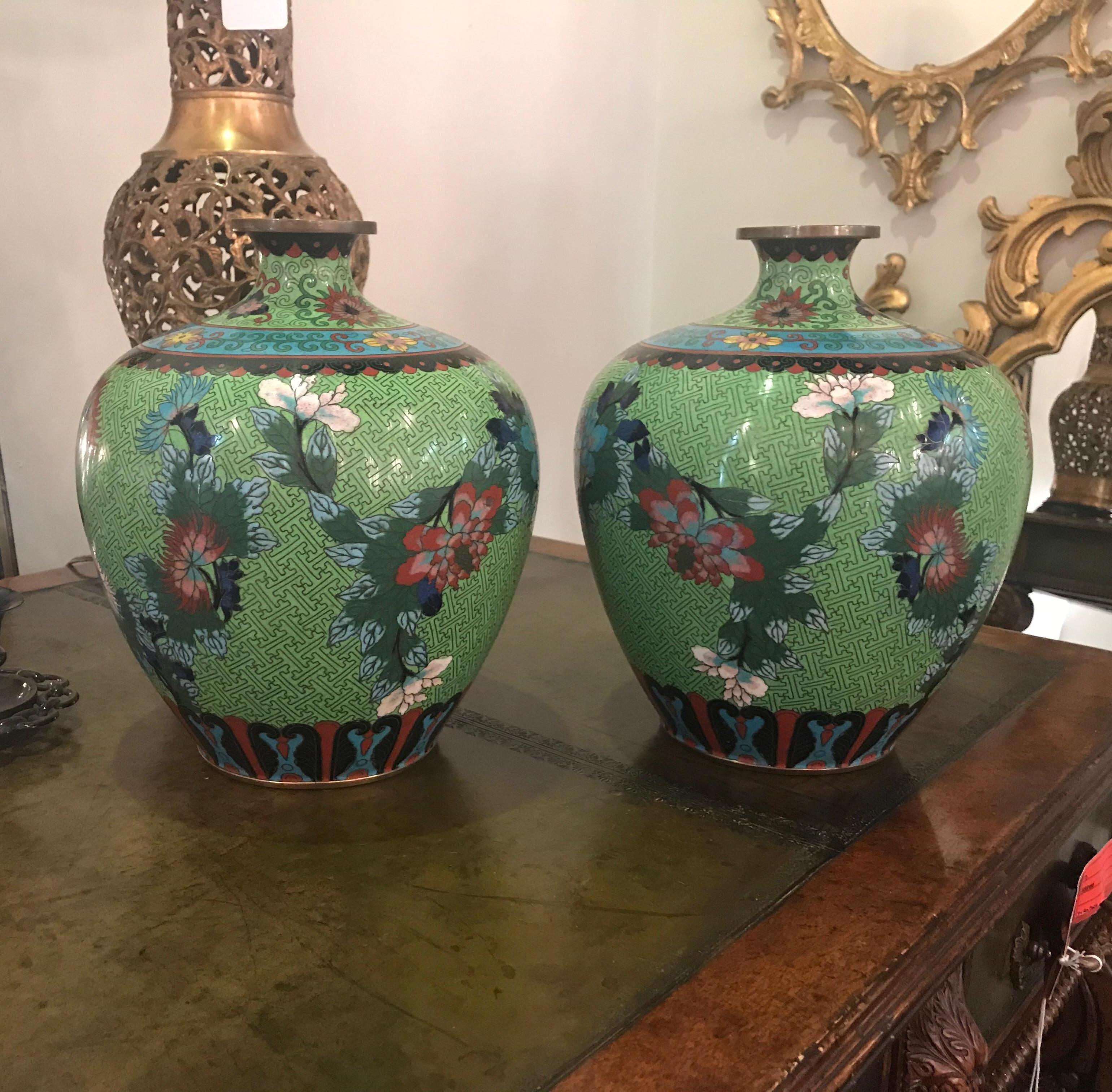 A larger pair of vibrantly colored circa 1910 Chinese cloisonne bulbous vases. The chartreuse background with iron red, celeste blue floral patters in mirror image of each. Great shape and unusual and rare color. 