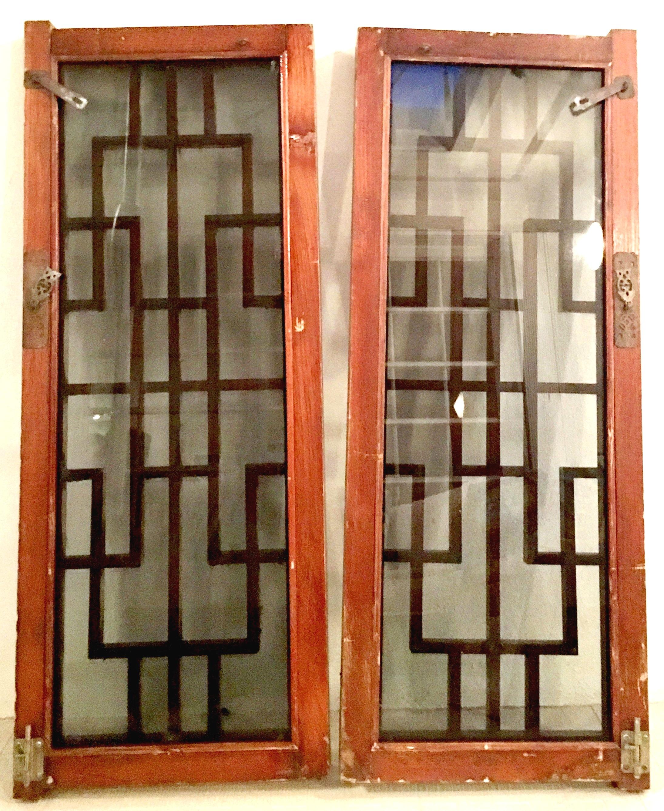 Antique Pair Of Chinese Carved Mahogany Window Panels. Features smoked colored glass and the and fantastic brass hardware. Brass hardware pulls are fantastic cut-out figural owls. Carved geometric lattice wood work is 1