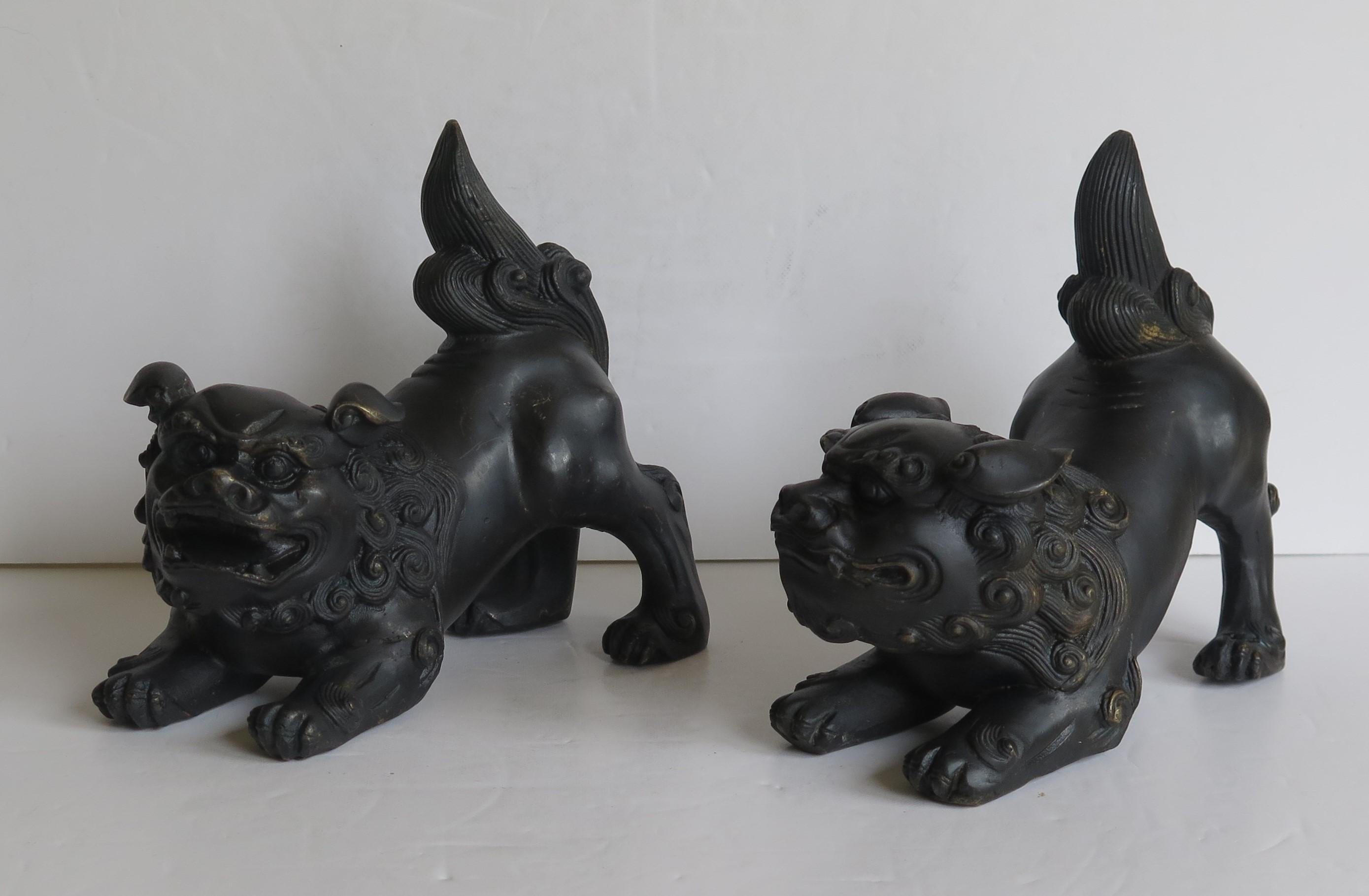 These are a very good pair of antique Chinese foo or lion dog sculptures, sometimes called temple lions, made of bronze, with good detail, dating to the 19th century, Qing period.

They are a male and female pair, the male with the slightly larger