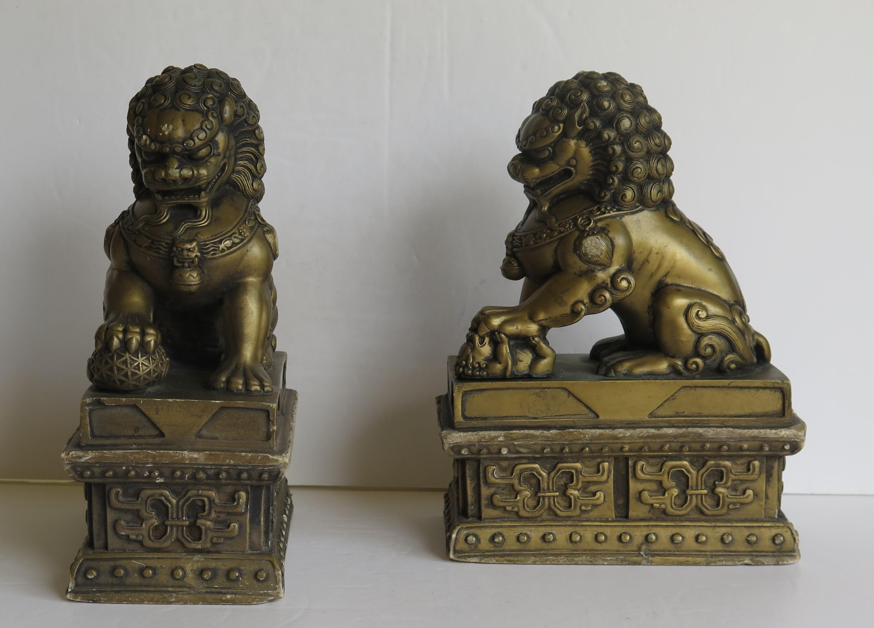 These are a very good pair of antique Chinese foo or lion dogs, sometimes called temple lions made of stone and hand gilded with fine detail, dating to the 19th century, Qing period.

They are a male and female pair, sitting on rectangular