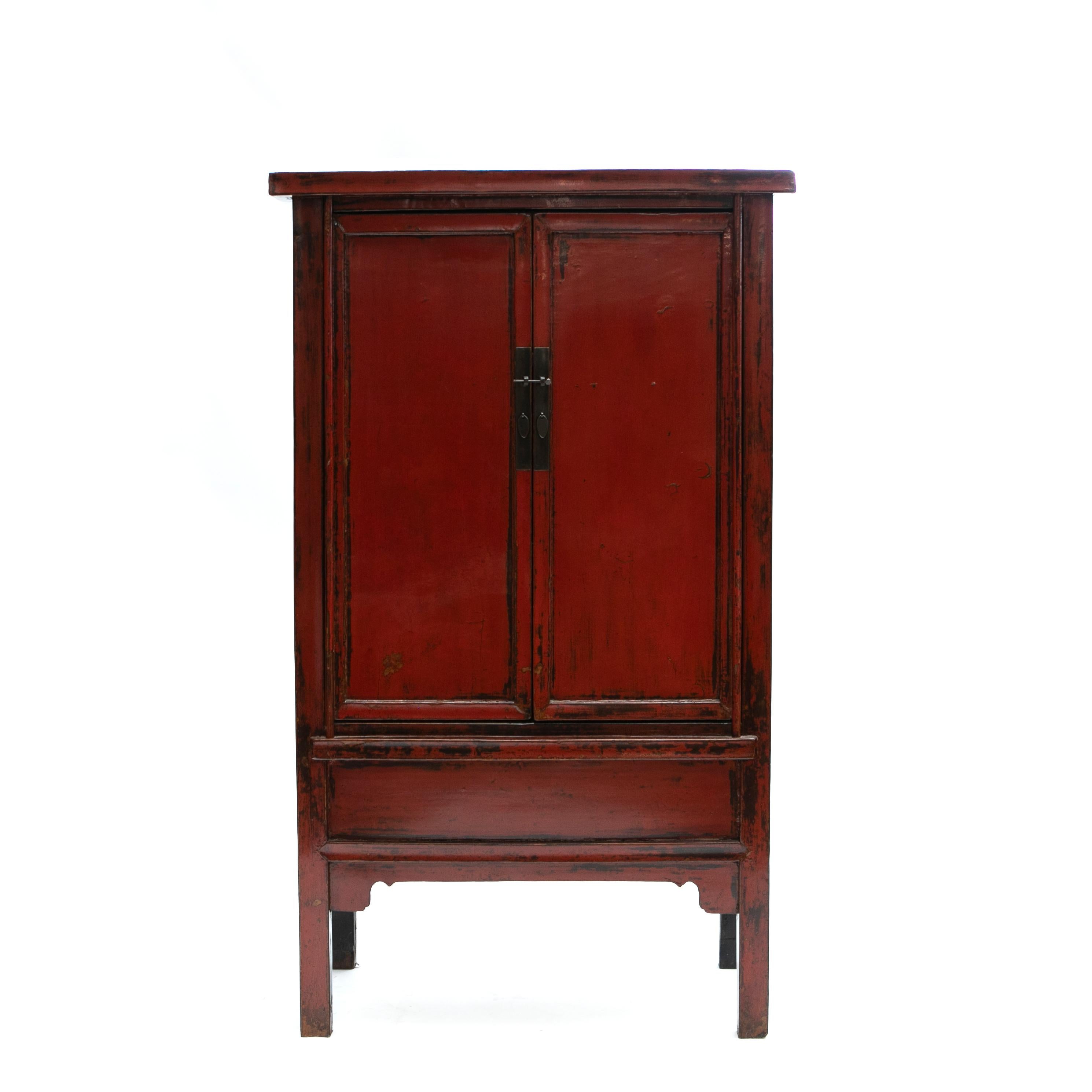 A stunning and pair of Chinese early 19th century cabinets features a red lacquer front contrasted by black lacquer sides.
Each cabinet showcases a pair of doors that open thanks to a metal lock to reveal inner shelves and a lower compartment