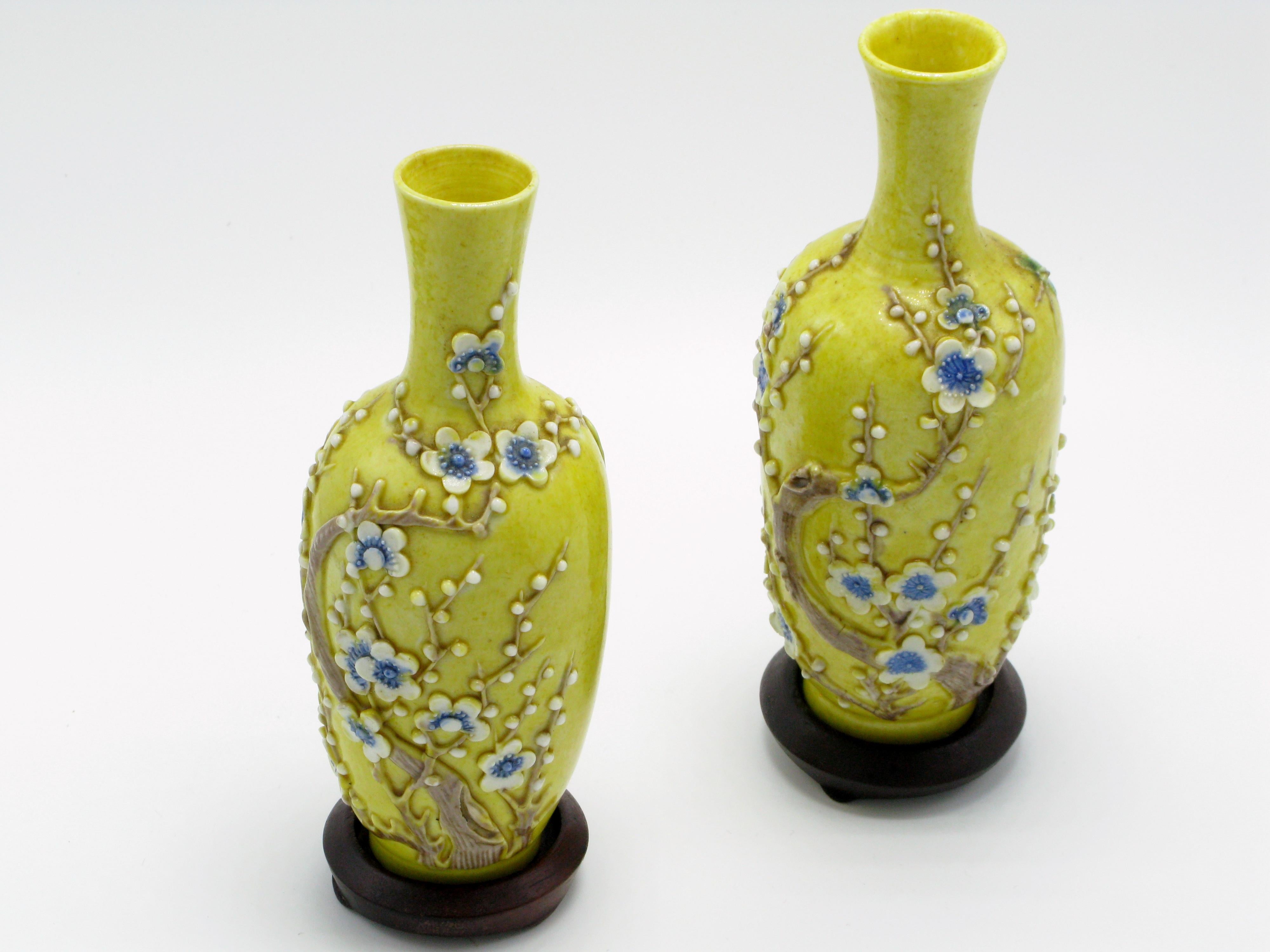 Lovely pair of miniature Chinese yellow ground porcelain vases with applied plum blossom trees and butterflies. Each Stand on circular rosewood bases.
Marked China engraved into bottom and date late 19th early 20th century, circa 1890-1920.
Bottle