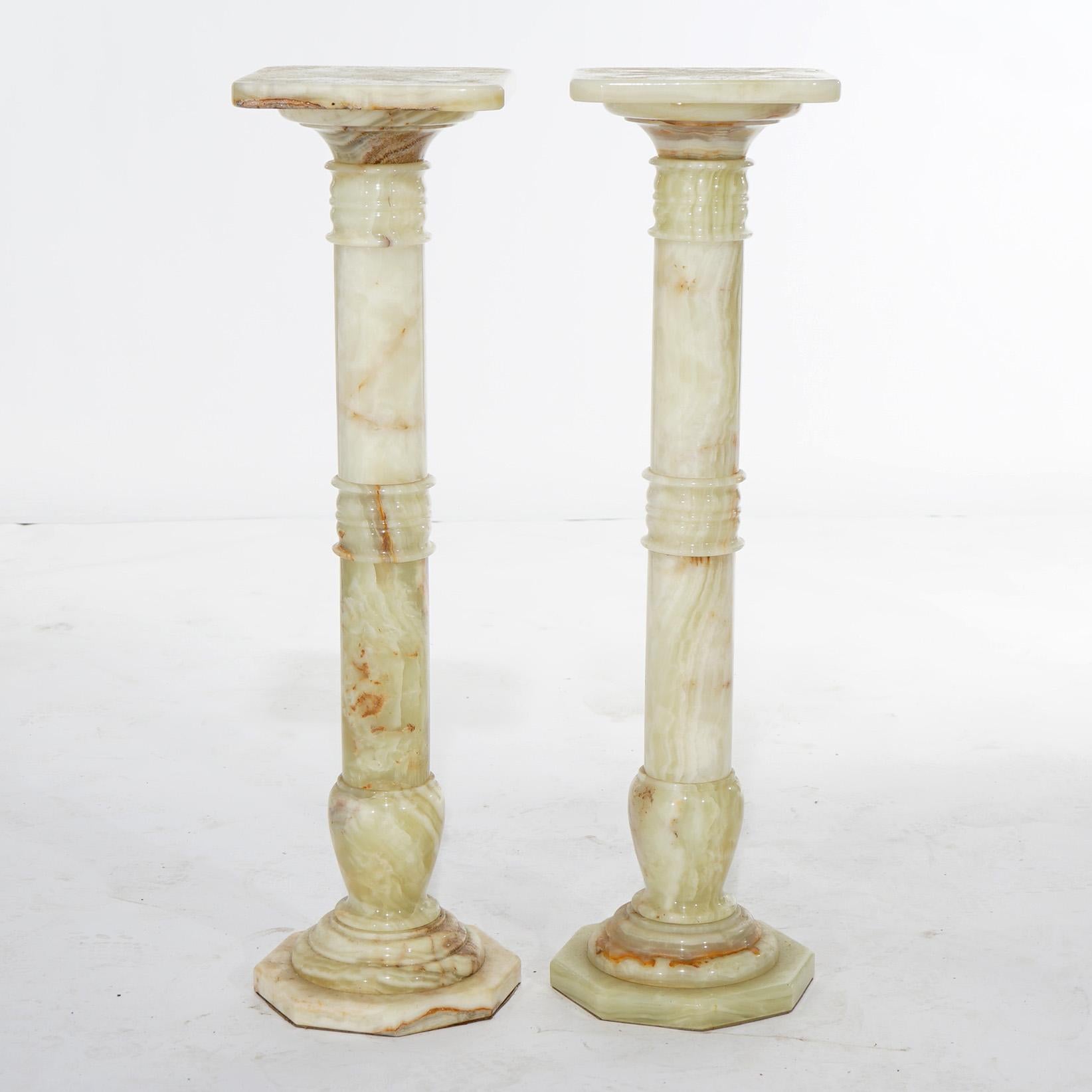 A pair of antique Classical pedestals offer onyx construction in Grecian form with square display platforms over banded bases with octagonal feet, 20th century

Measure - 38