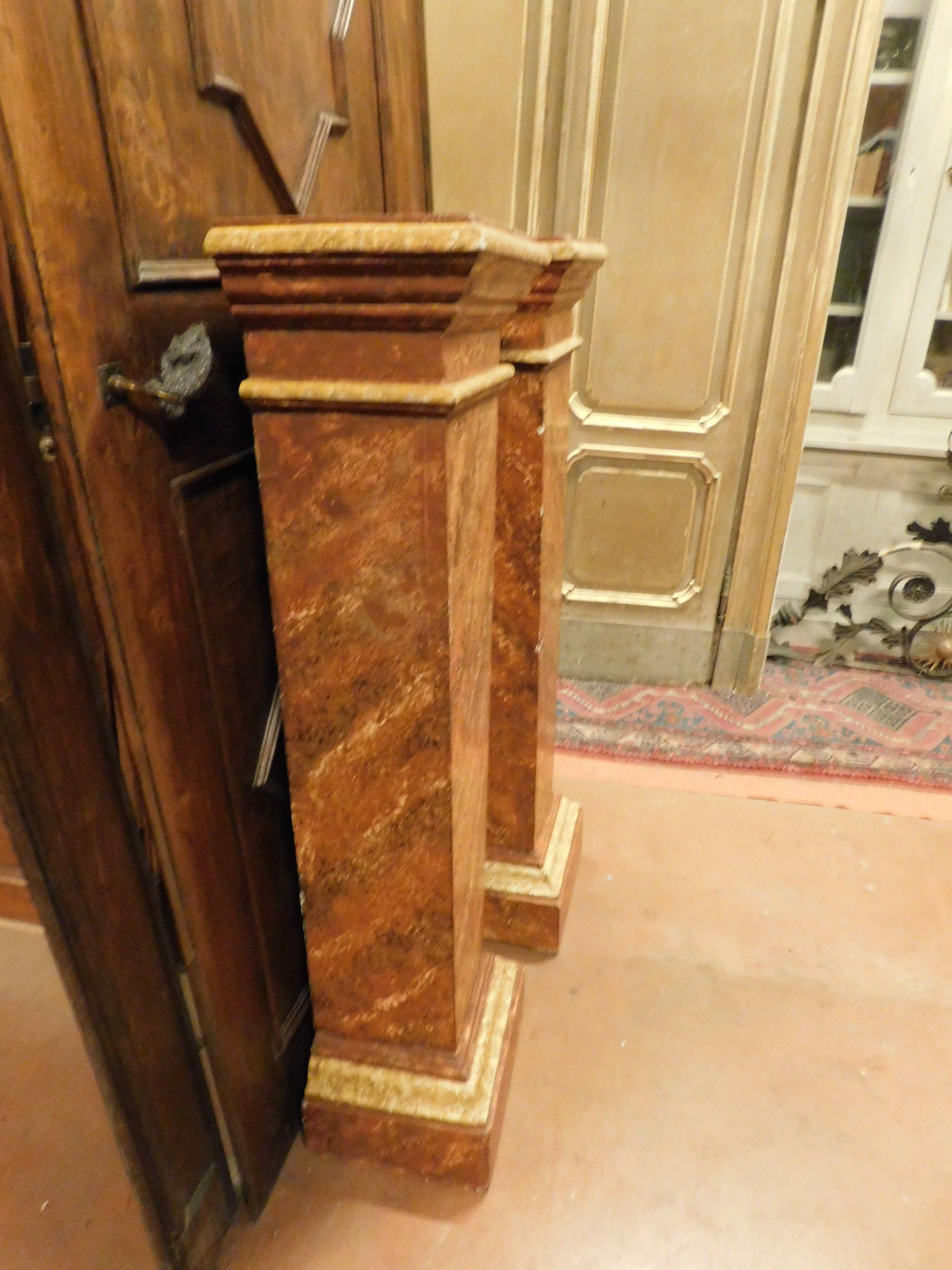 Ancient pair of wooden columns, lacquered in fake orange marble, with a smaller base than the hat, a shelf suitable for displaying statues or vases, made in the 19th century in Italy.