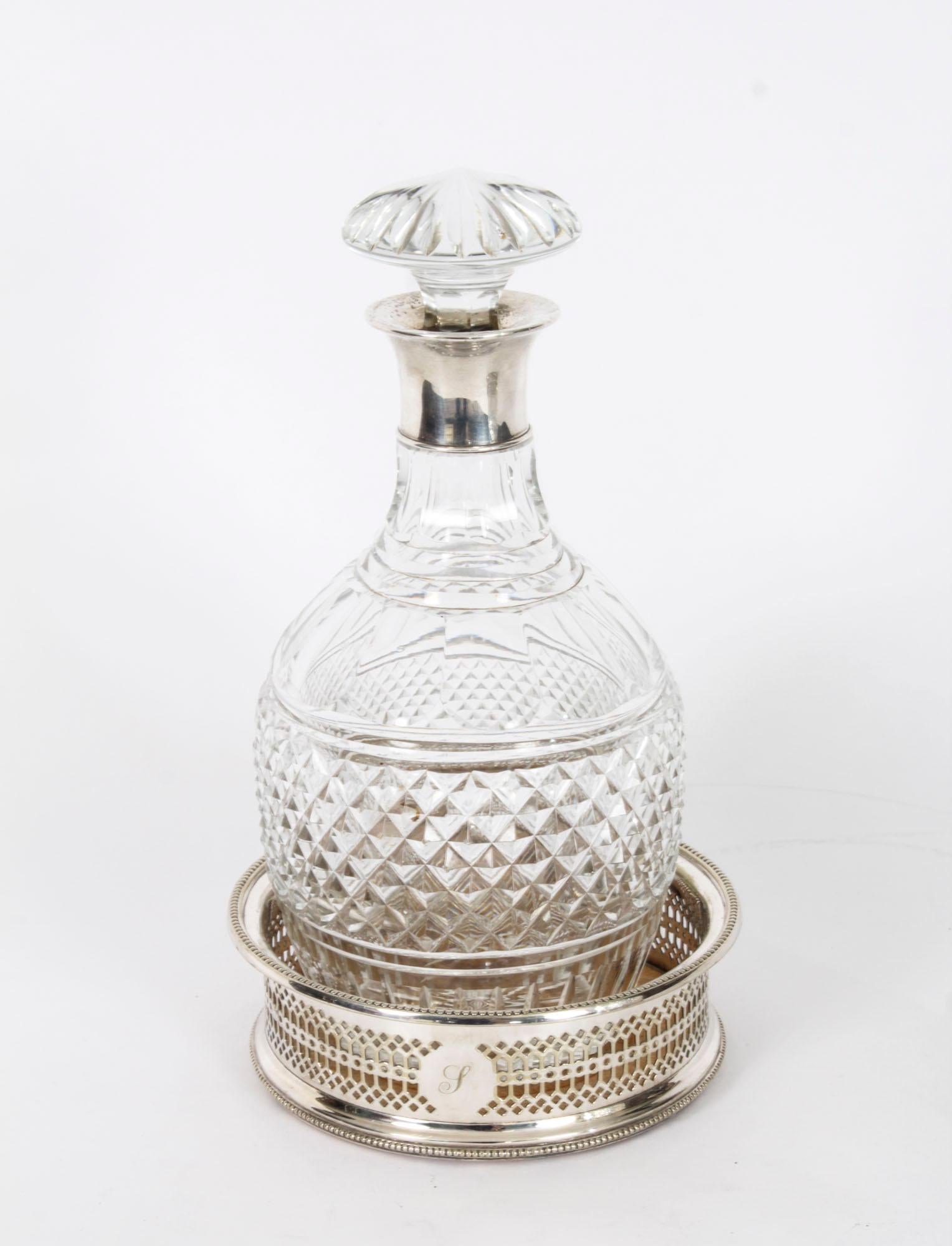A superb pair of sterling silver mounted diamond pattern crystal decanters and coaster set, 19th century in date. 

The tapering cylinder shaped diamond pattern crystal decanters feature sterling silver mounted rims with faceted globular glass
