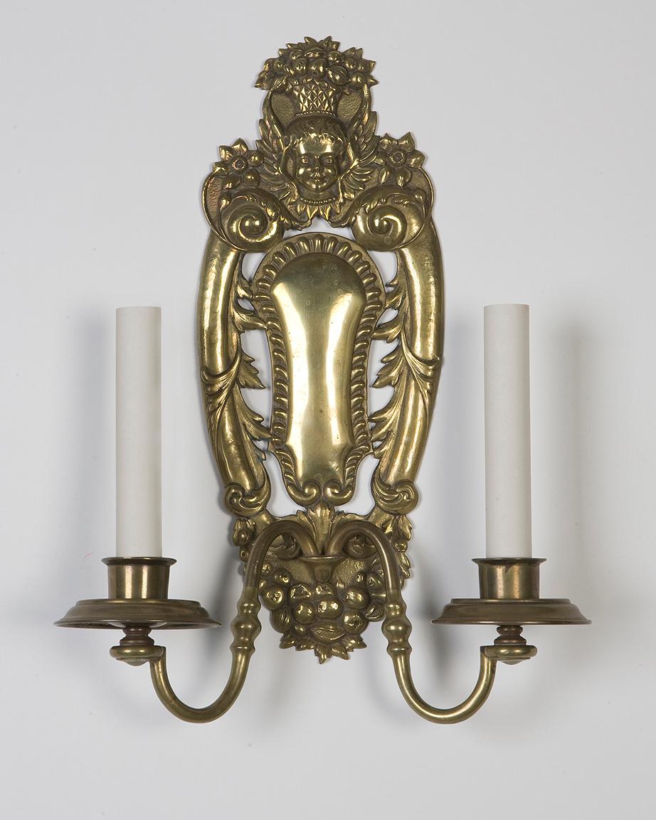 AIS2699
A pair of double light sconces in their original aged brass finish, having openwork backplates detailed with fruit and foliate motifs arounds a central gadrooned cartouche. Attributed to the New York maker E. F. Caldwell.