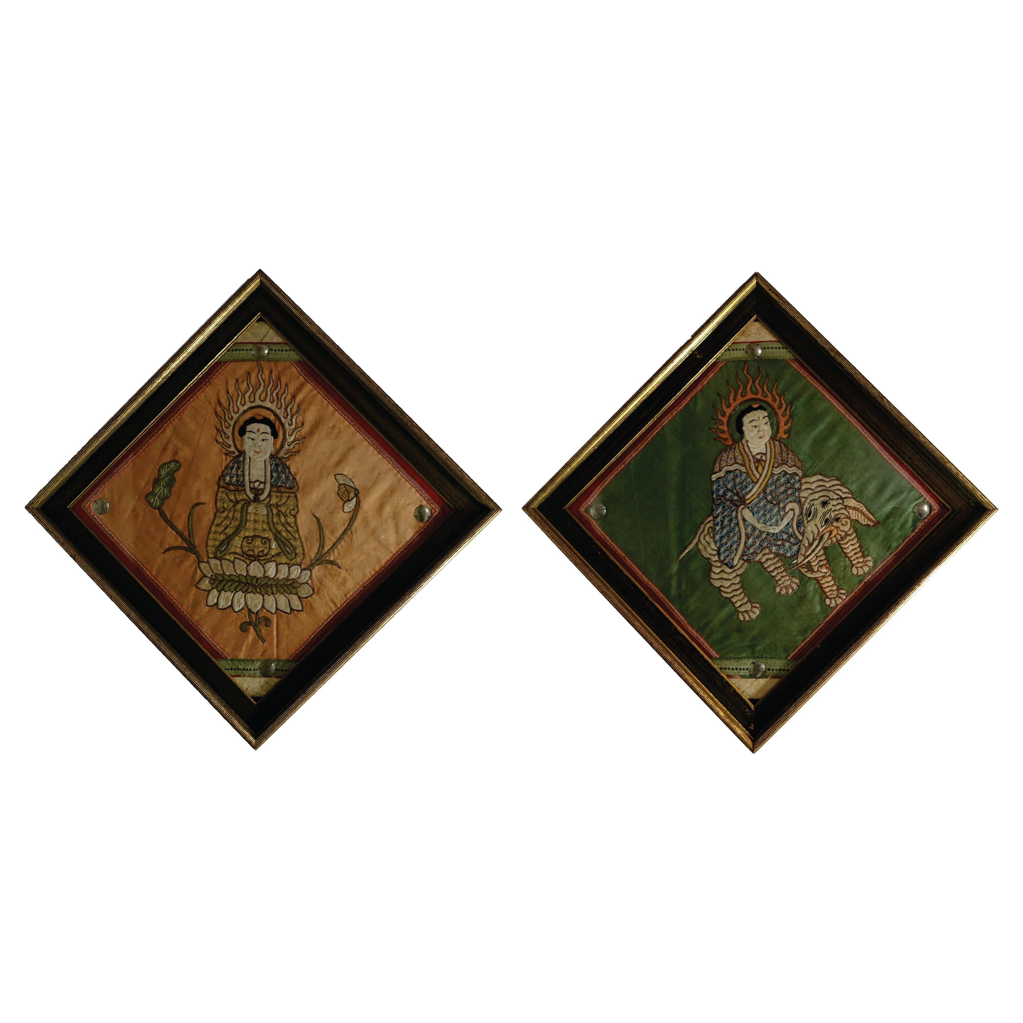 Antique pair of embroidered panels of Buddhas, presenting Buddha appears in two different forms, one is sitting on the lotus and one is ridding on a mythological creature. They are framed and with glass.