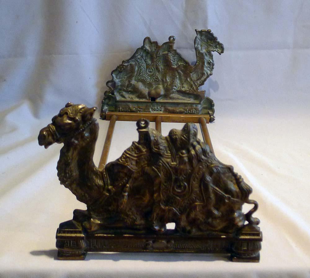 Antique pair of English bookends in the shape of a camel. Beautifully cast in bronze, each camel is fully dressed with saddle harnesses and are shown sitting. Under each camel is the ancient Egyptian symbol of the winged Sun. The camel are attached