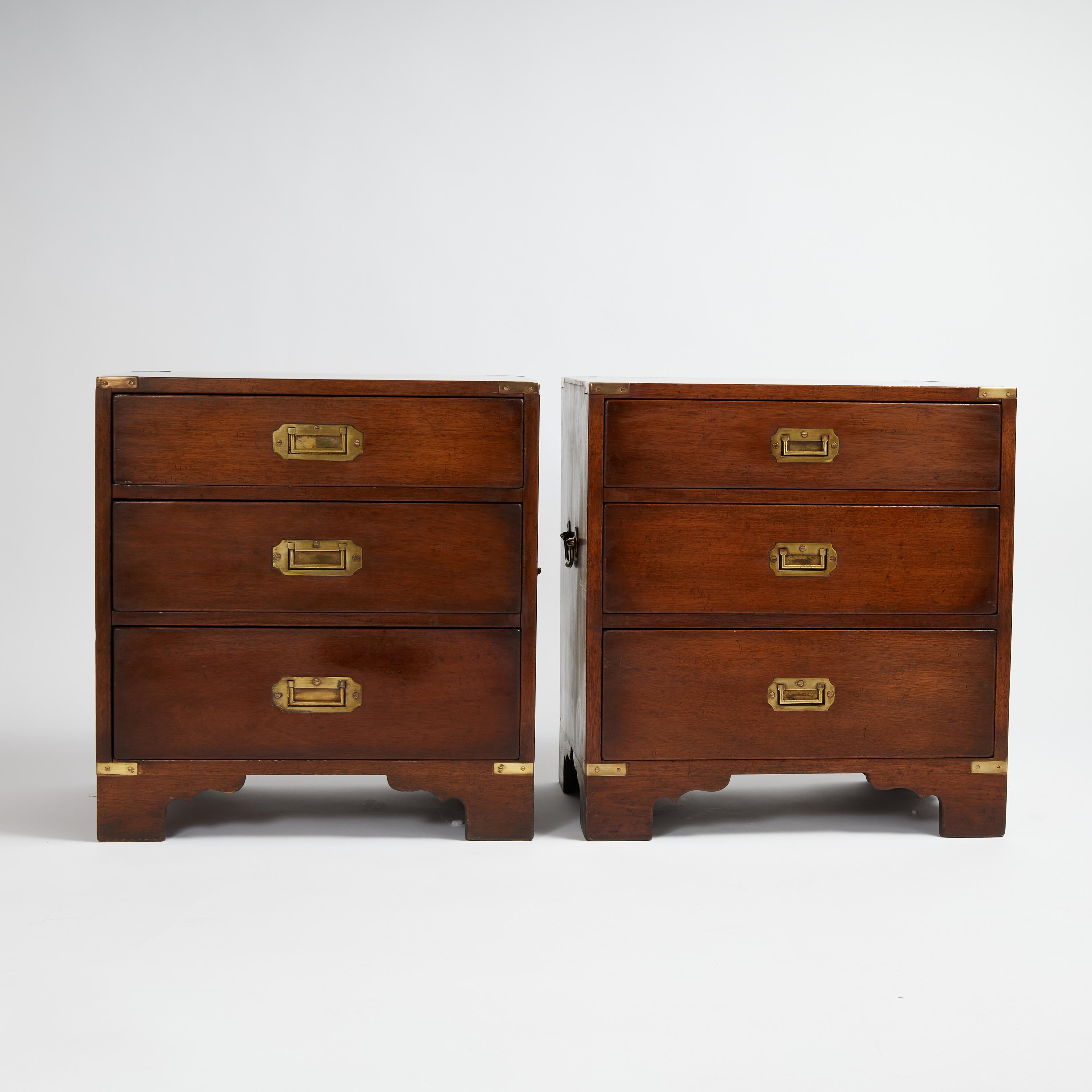 Handsome pair of 19th Century British Colonial stands handcrafted in mahogany in classic form with three drawers, campaign brass hardware and bracket feet. French polishes in the traditional old world manner. 