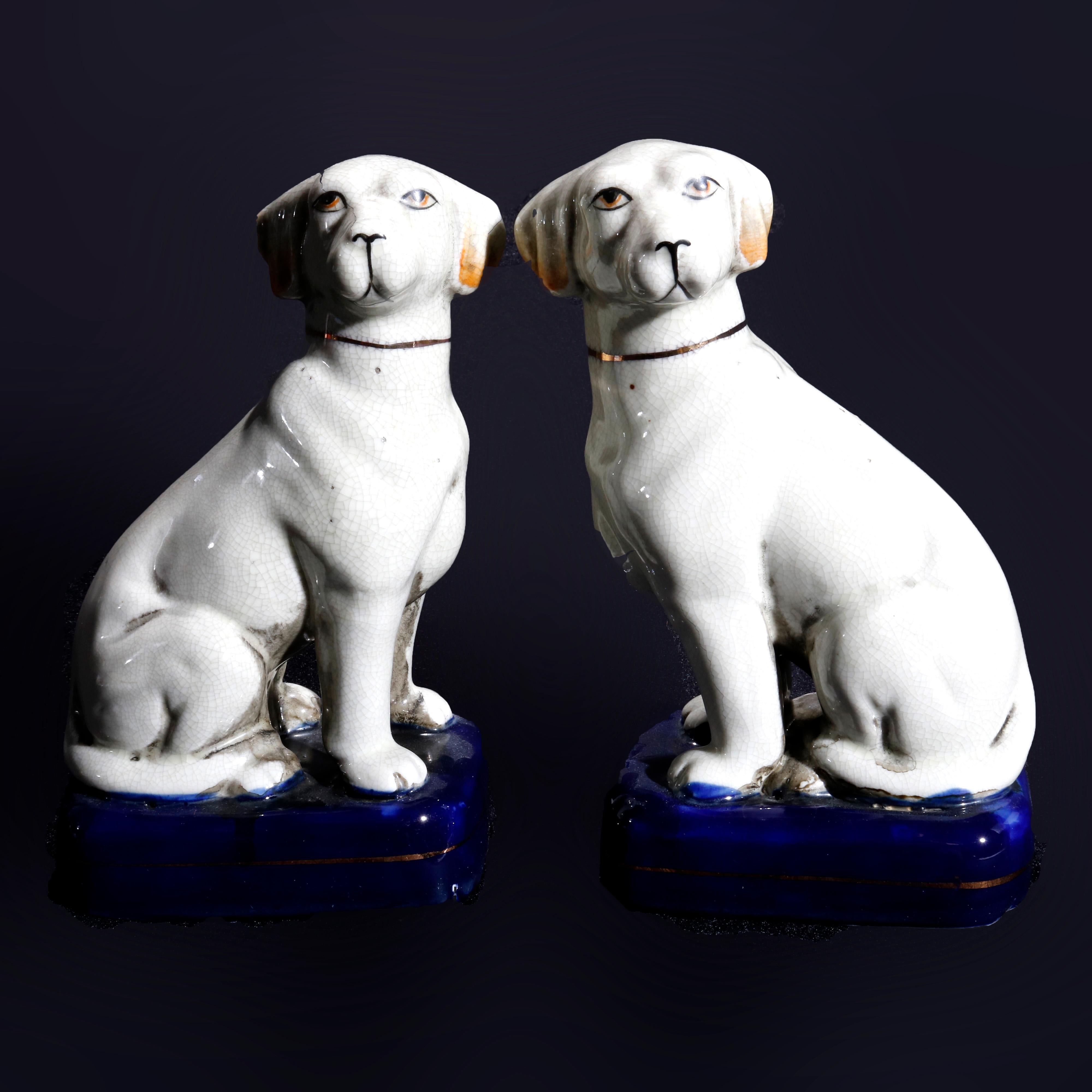 An antique pair of English Staffordshire porcelain figures depict seated dogs on cobalt plinth, 20th century.

Measures: 8