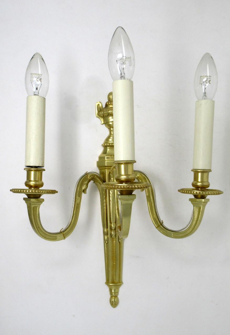 Fine quality pair of English gilt bronze three-arm wall candle sconces lights, of generous proportions, late Nineteenth, early 20th century. 

The three leaf capped scroll arms issuing from a well-cast single decorative tapering column backplate