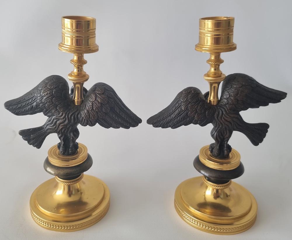 Paire de chandeliers anciens de style Régence anglaise en forme d'aigle avec vipère en bronze doré et patiné. L'aigle, très bien modélisé, dont les ailes et la tête ont été finement travaillées, possède toujours ses deux vipères (qui sont souvent