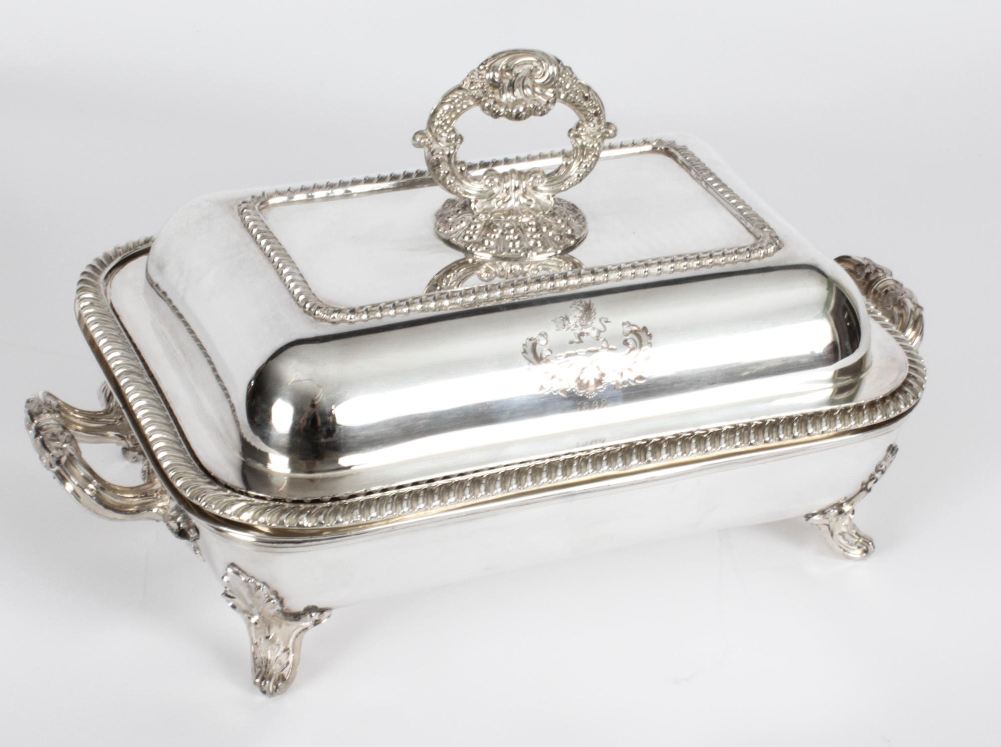 This is an exquisitely high-quality antique pair of English silver plated on copper entree dishes, each with an engraved crest, dated 1868.

These stunning rectangular entree dishes feature impressive gadrooned borders and foliate cast handles,