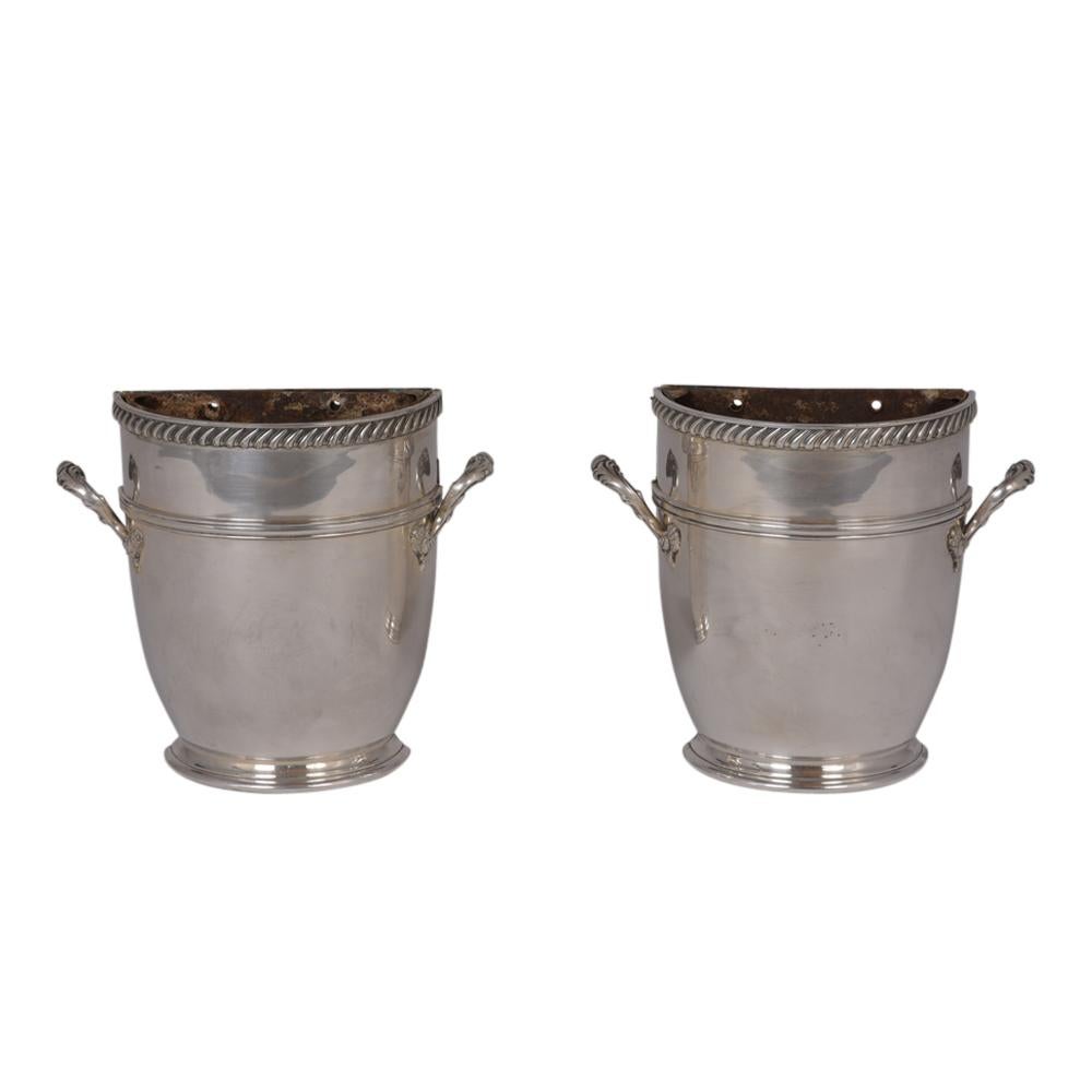 This antique pair of English Regency style jardinières have an elegant urn design and are plated in silver. Inside are removable liners that allow for easier cleaning. This pair of jardinières are sturdy, elegant, and ready to be used for years to