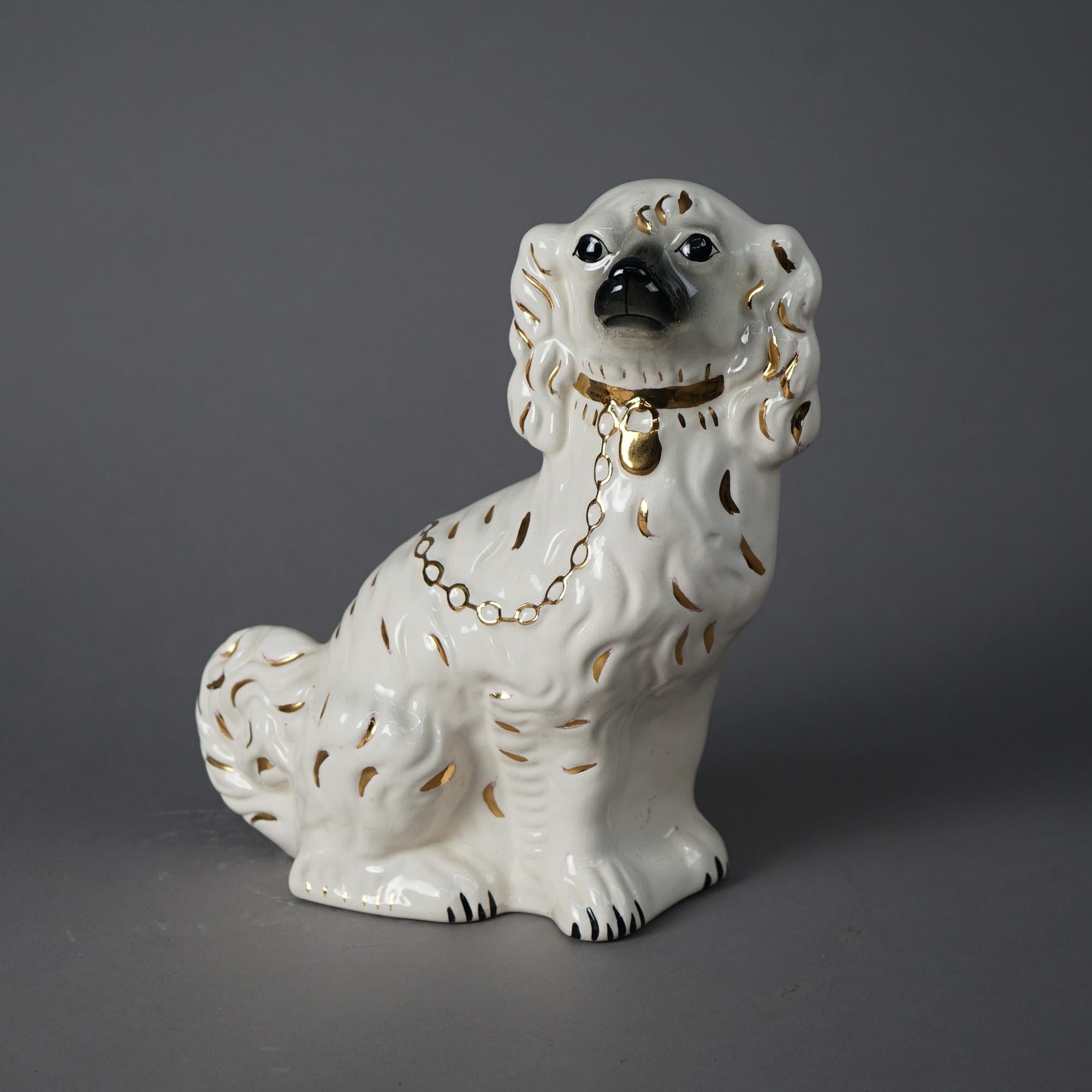 A pair of English Staffordshire dogs offer porcelain construction in Spaniel form, hand painted with gilt highlights, 20th century.

Measures - 11.25