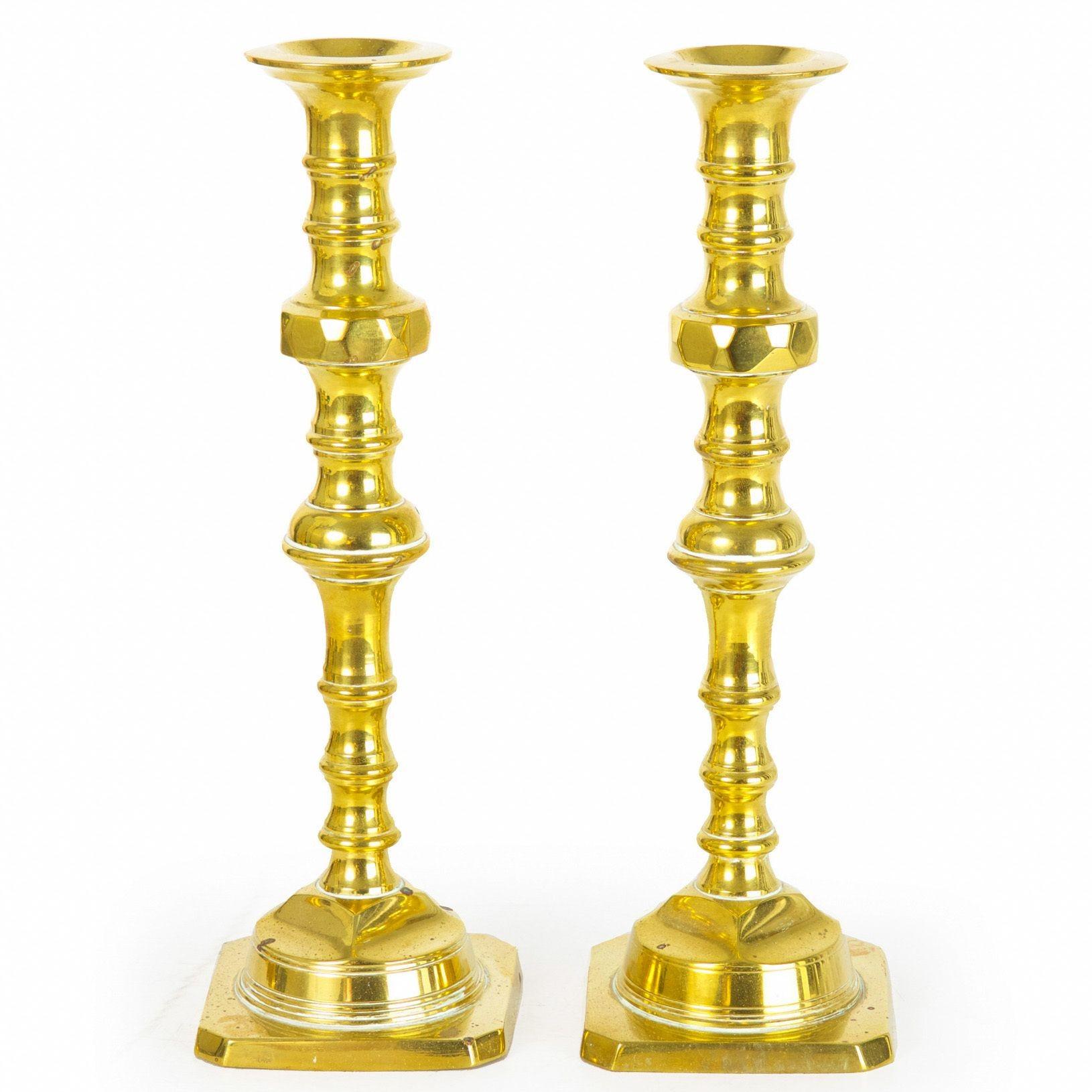 A most attractive pair of English candlesticks in the Neoclassical taste from the late 19th century, they are crafted of solid brass that has been beautifully hand-turned with a series of ring-turnings, a swollen baluster and an upper faceted