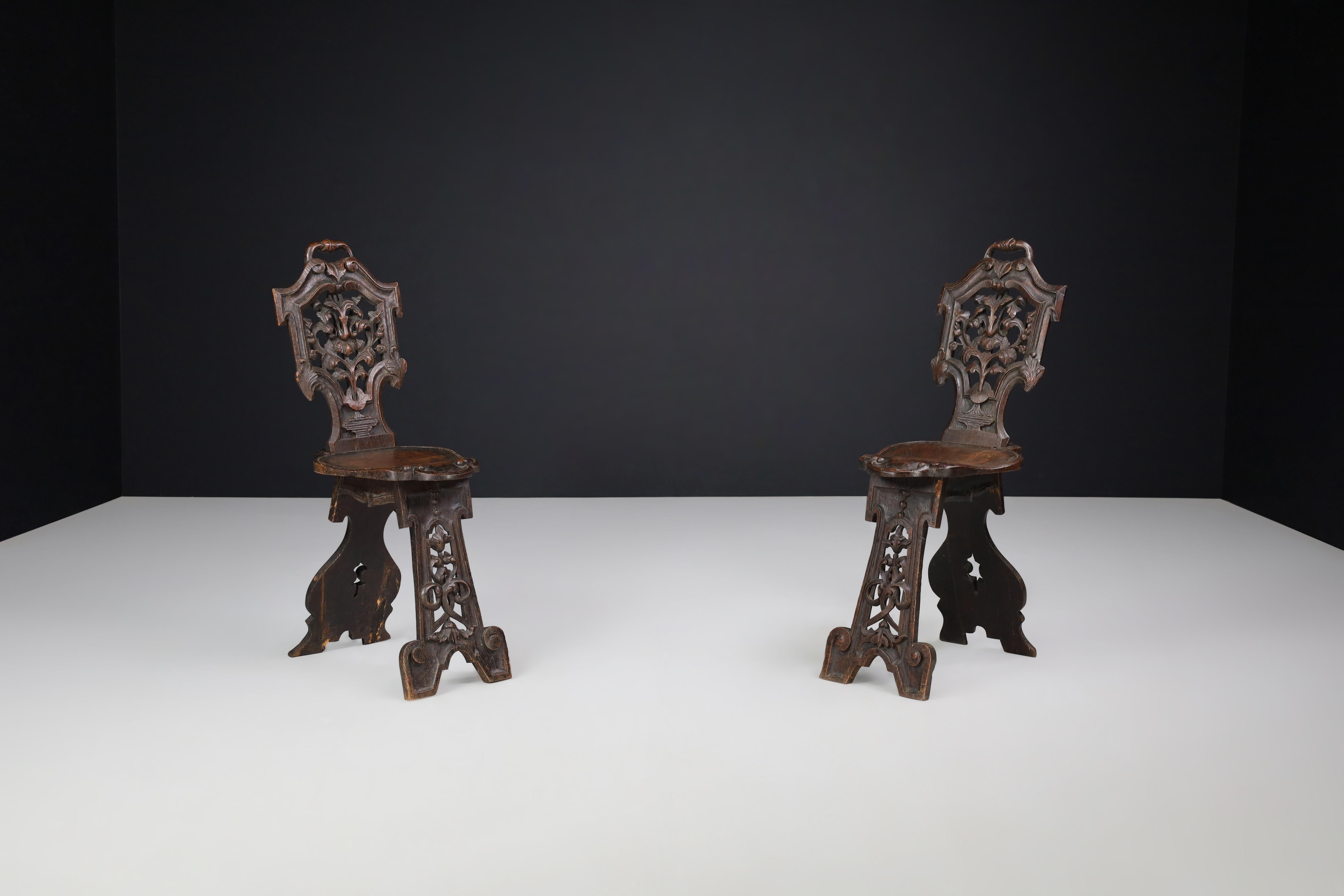 Antique Pair of Figural Heavily Carved Walnut Sgabello Chairs with Baroque Motifs, 18th–19th Century

A stunning pair of figural sgabello chairs, intricately carved from rich walnut and dating from the late 18th to early 19th century. These
