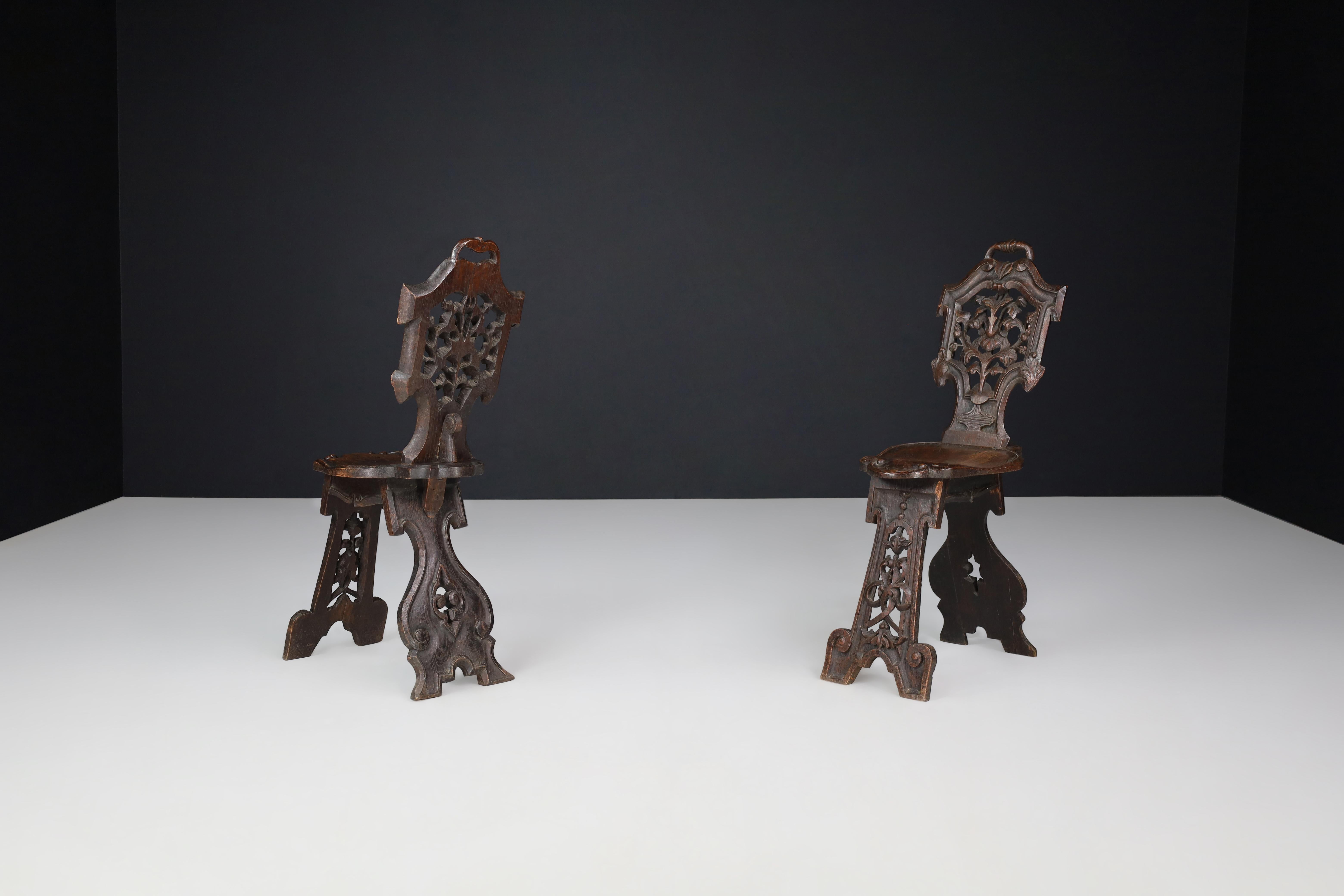 Italian Antique Pair of Figural Heavily Carved Oak Sgabello Chairs Italy For Sale