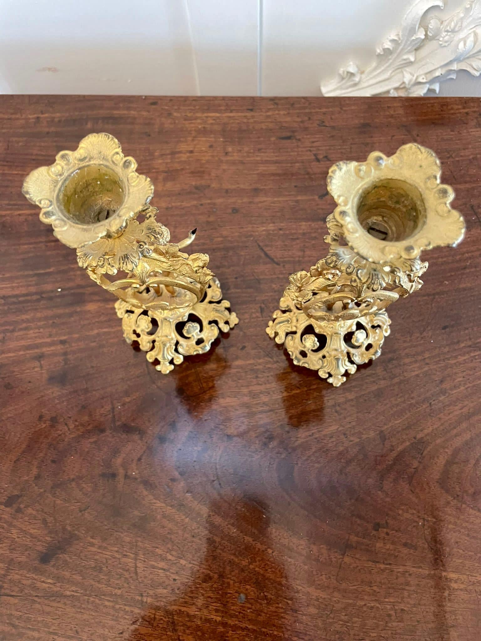Antique pair of fine French Victorian ornate gilded candlesticks with delightful ornate cupids and flowers.   The candlesticks have attractive shaped tops raised by cupids on an ornate base.

A quaint decorative pair beautifully