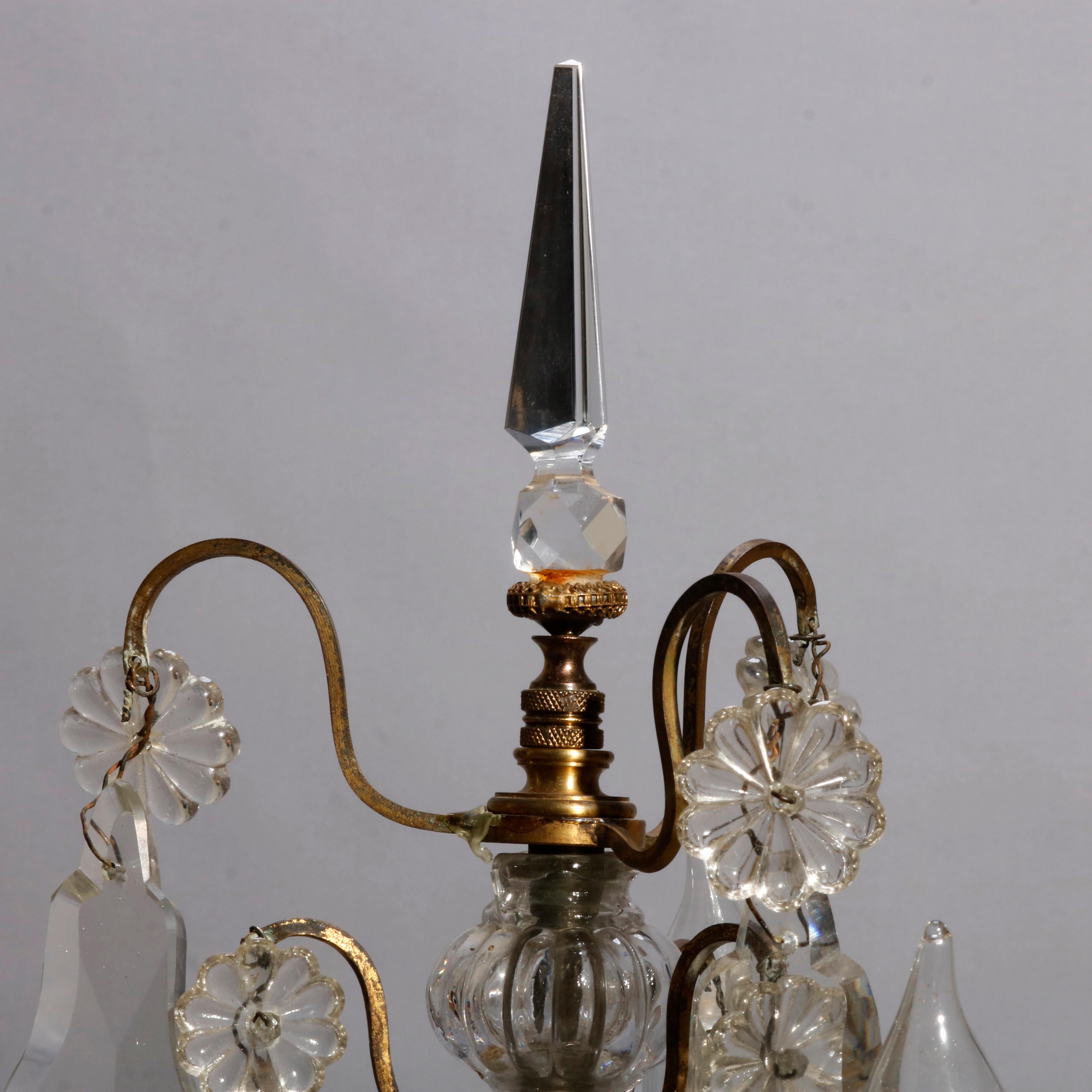 An antique pair of French candelabras table lamps offer bronzed frame with scroll form arms terminating in candle lights and raised on flared foot, cut crystals throughout, circa 1910

Measures: 21.5