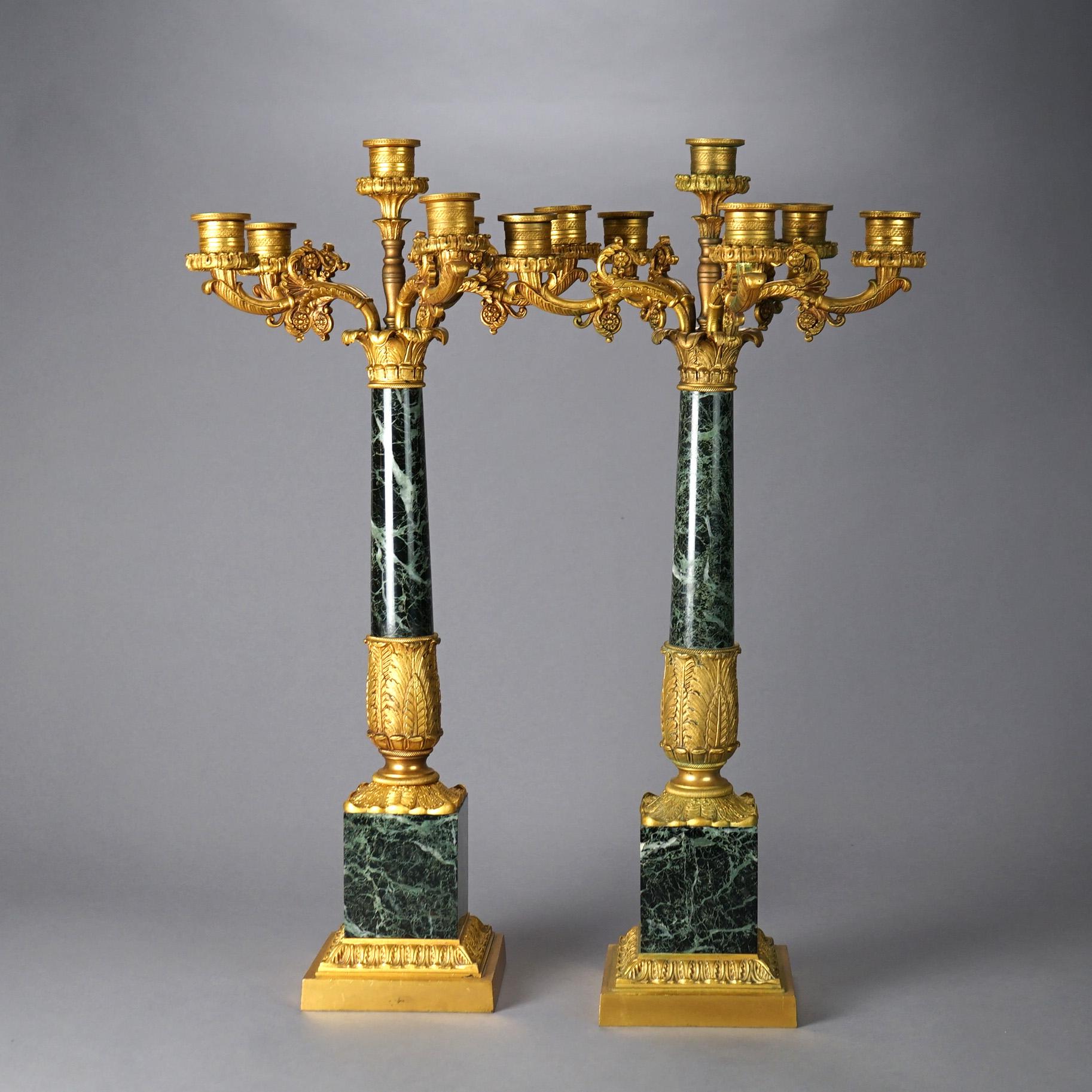 Ein antikes Paar französischer Empire-Kandelaber bietet vergoldete Bronzearme über Marmorsäulen, 19.


Maße - 26,75 