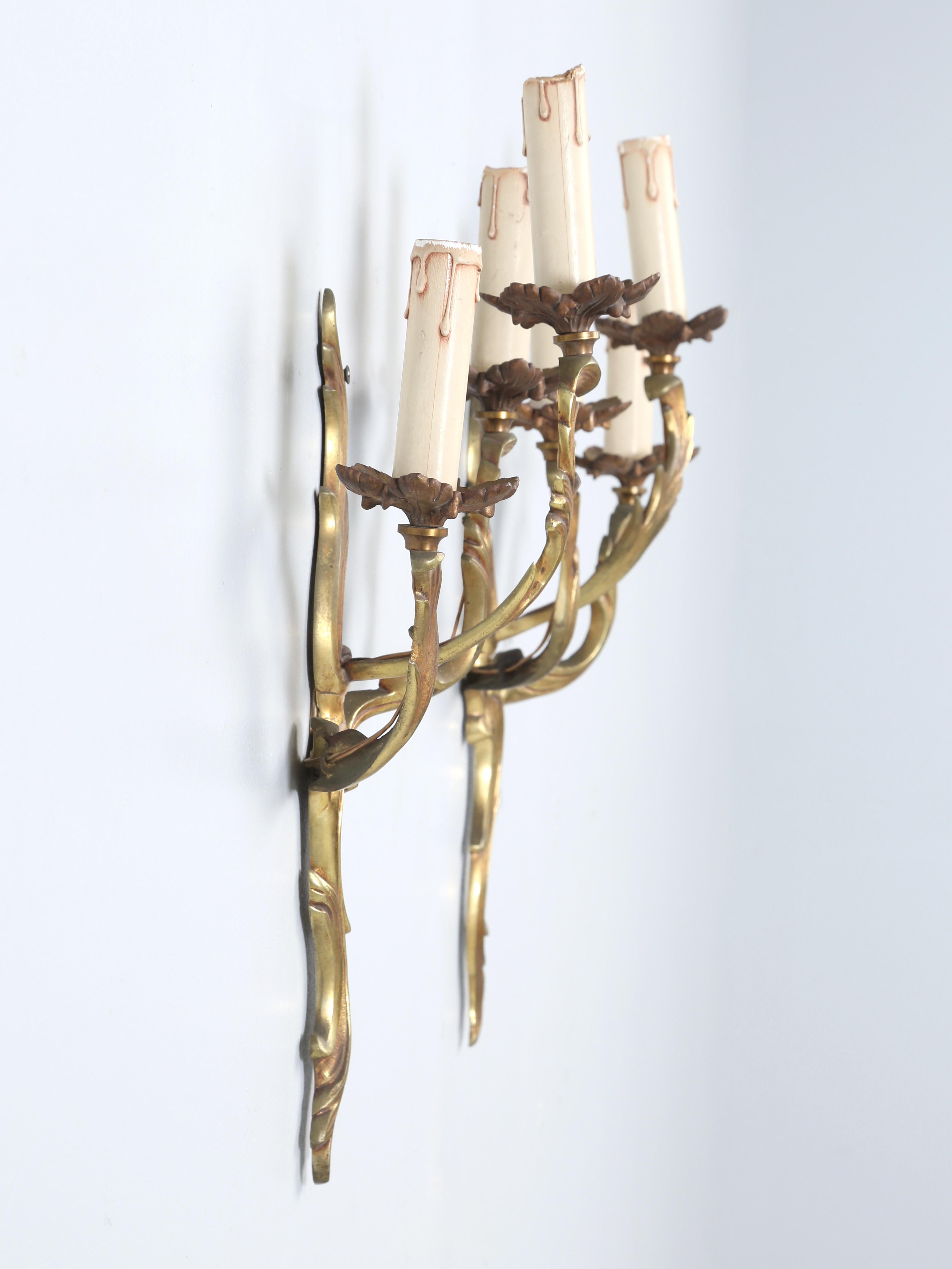 Paire d'appliques en bronze de style Louis XV ou Rococo, avec deux ampoules de taille candélabre chacune, vers 1880-1920. Les appliques en bronze de style Rococo ou Louis XV ont été dorées, mais en raison de leur âge, elles se sont oxydées au fil