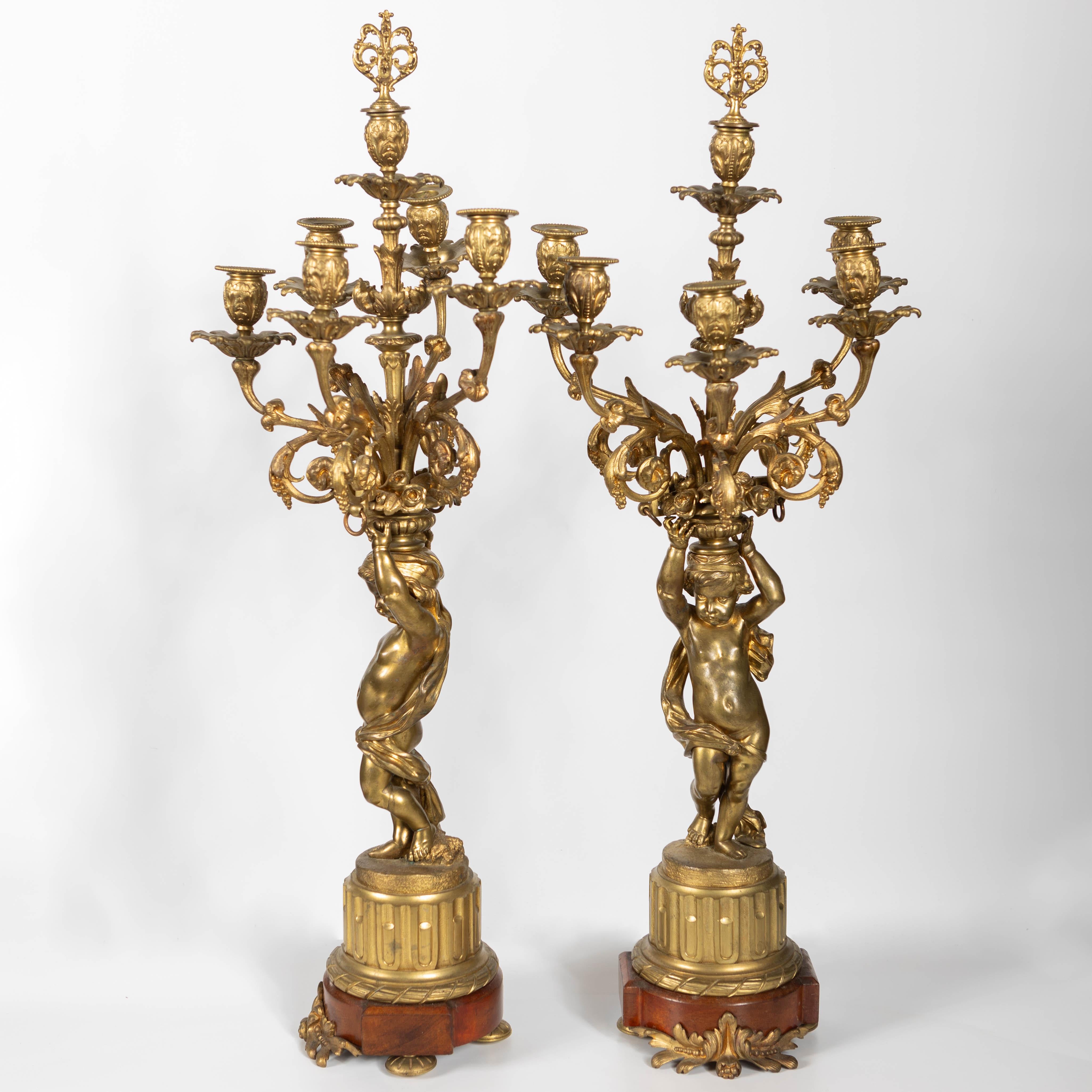 Eleva i tuoi interni con questa squisita coppia di candelabri francesi in bronzo dorato del XIX secolo, una magnifica rappresentazione dell'opulenza e della maestria dell'epoca di Napoleone III. Risalenti al 1870 circa, questi pezzi riccamente