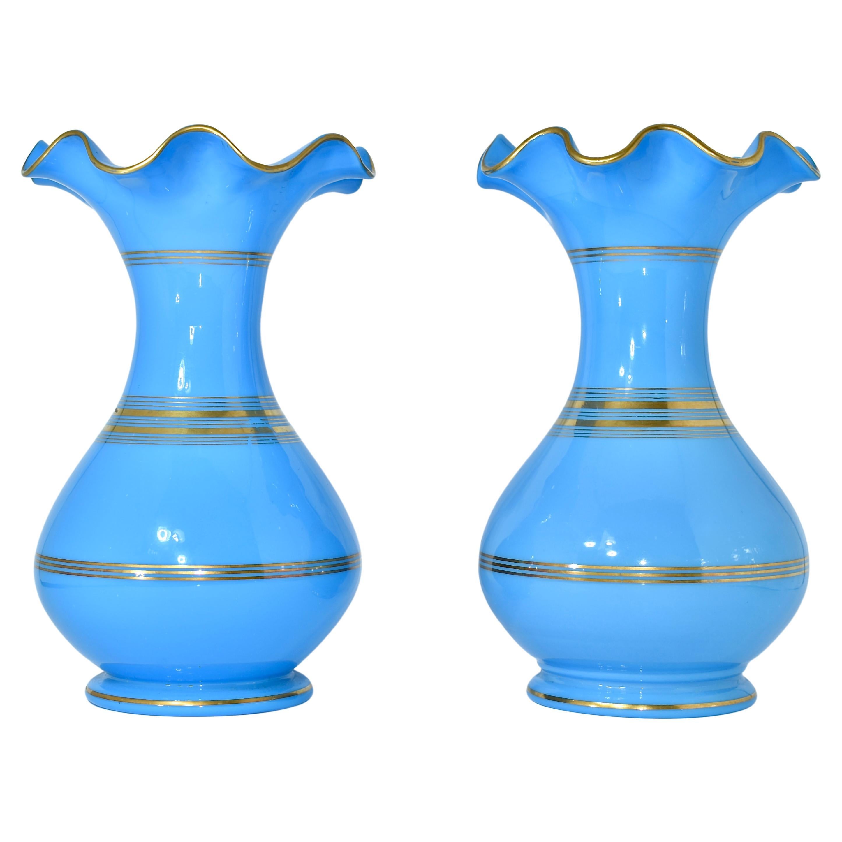 A set of 2 matching opaline glass vases

Beautiful Blue color with gilding highlights decoration and wavy scalloped rims

France, 19th Century

Measures 23 cm high