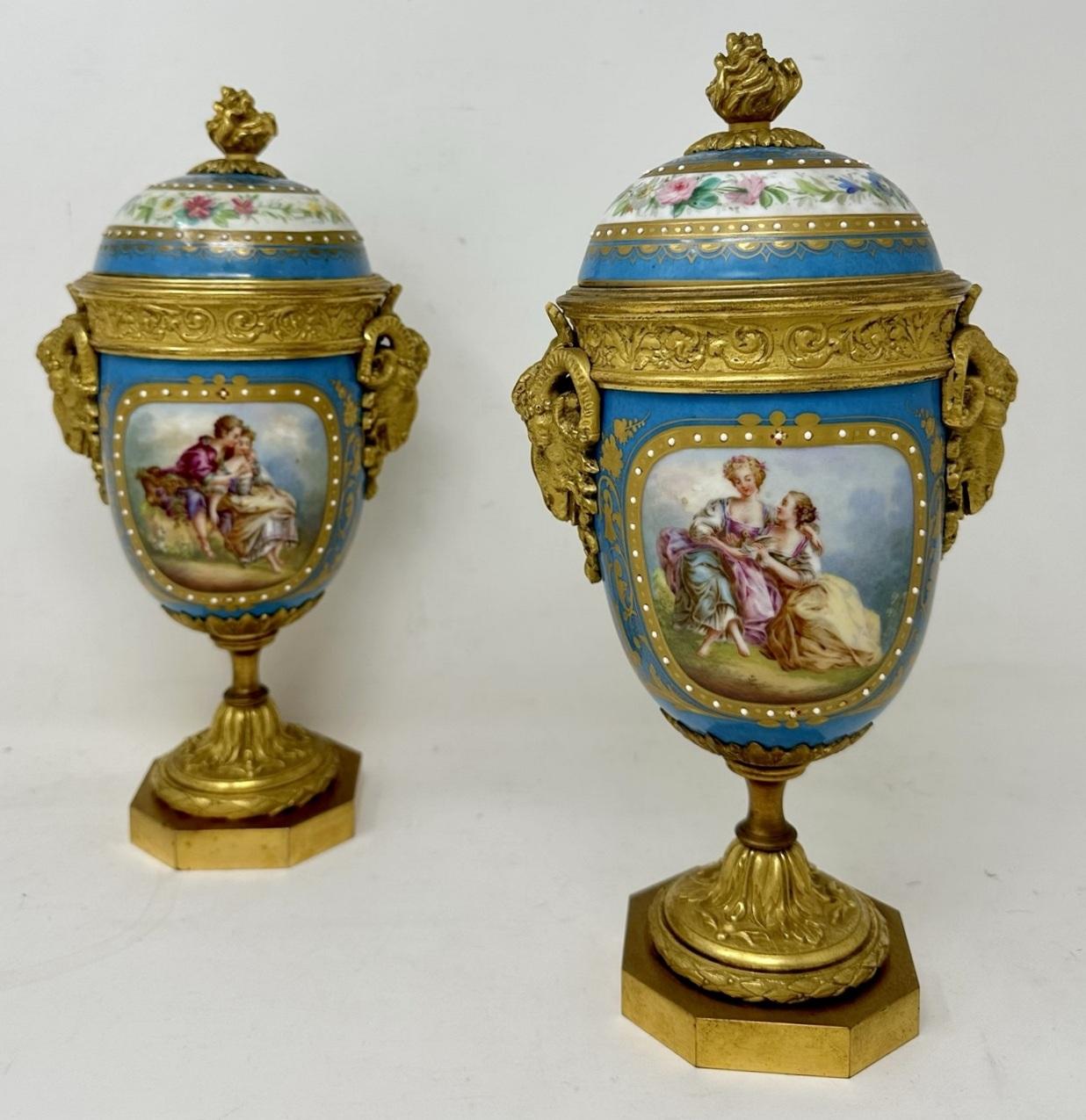 Stunning Pair of French Sevres Soft Paste Enamelled Porcelain and Ormolu Twin Handle Table or Mantle Urns of traditional urn form and of outstanding quality, and good size proportions, each raised on a square stepped base with canted corners.